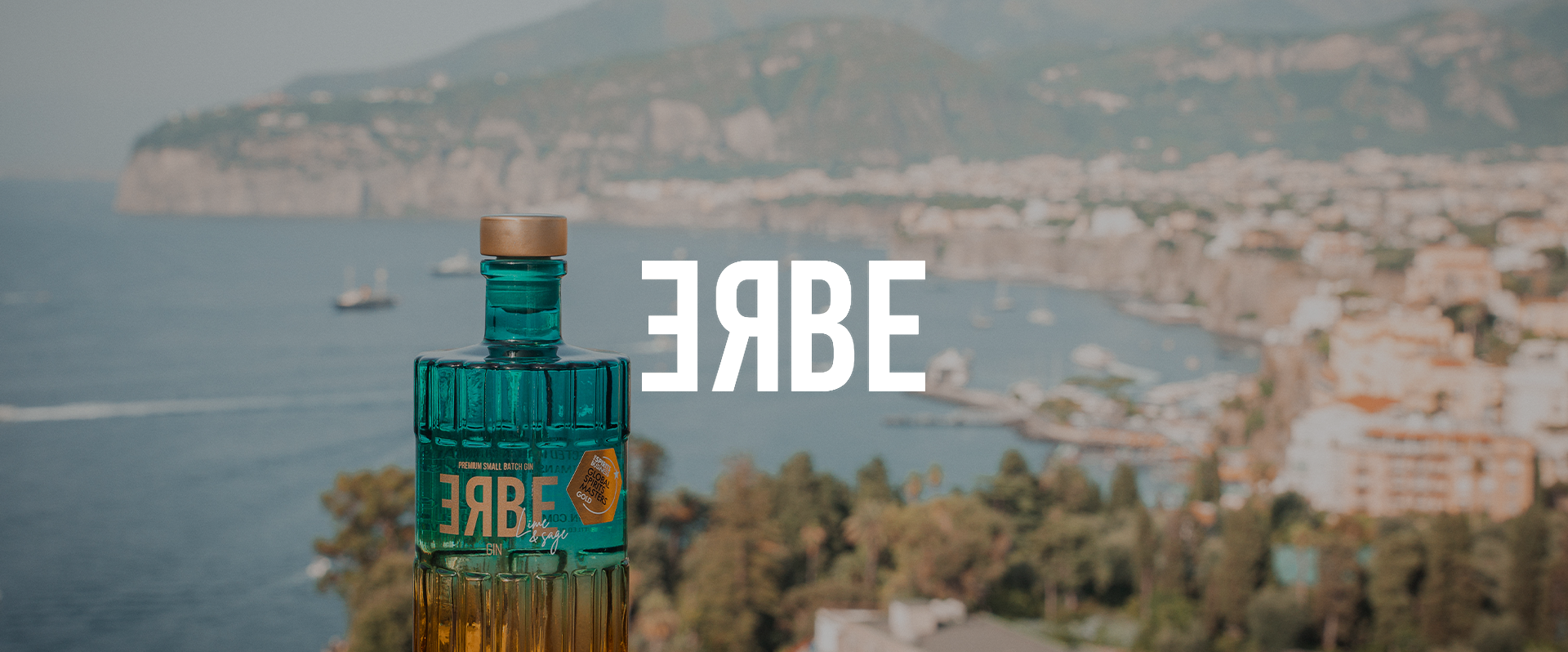 A teal bottle with a beige cap, labeled 'SABRE,' is set against a blurred coastal cityscape with boats in the water and hills in the background. The word 'SABRE' is upside down on the image.