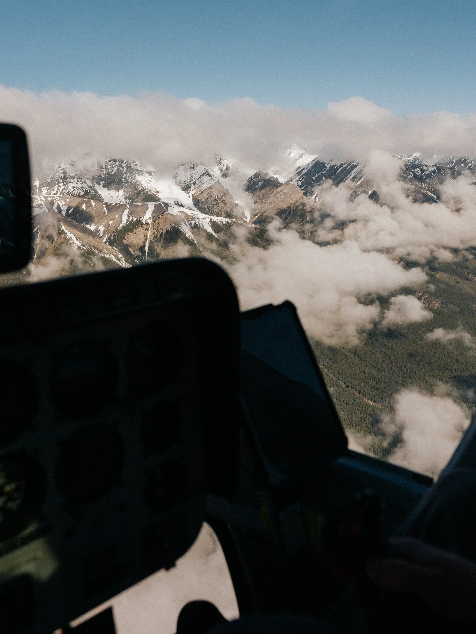 Mountains with snow and clouds from an aerial view, possibly taken from an aircraft.