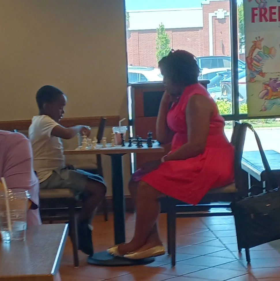 Kamai Hutson teaching his Mom how to play chess at Barnes and Noble.