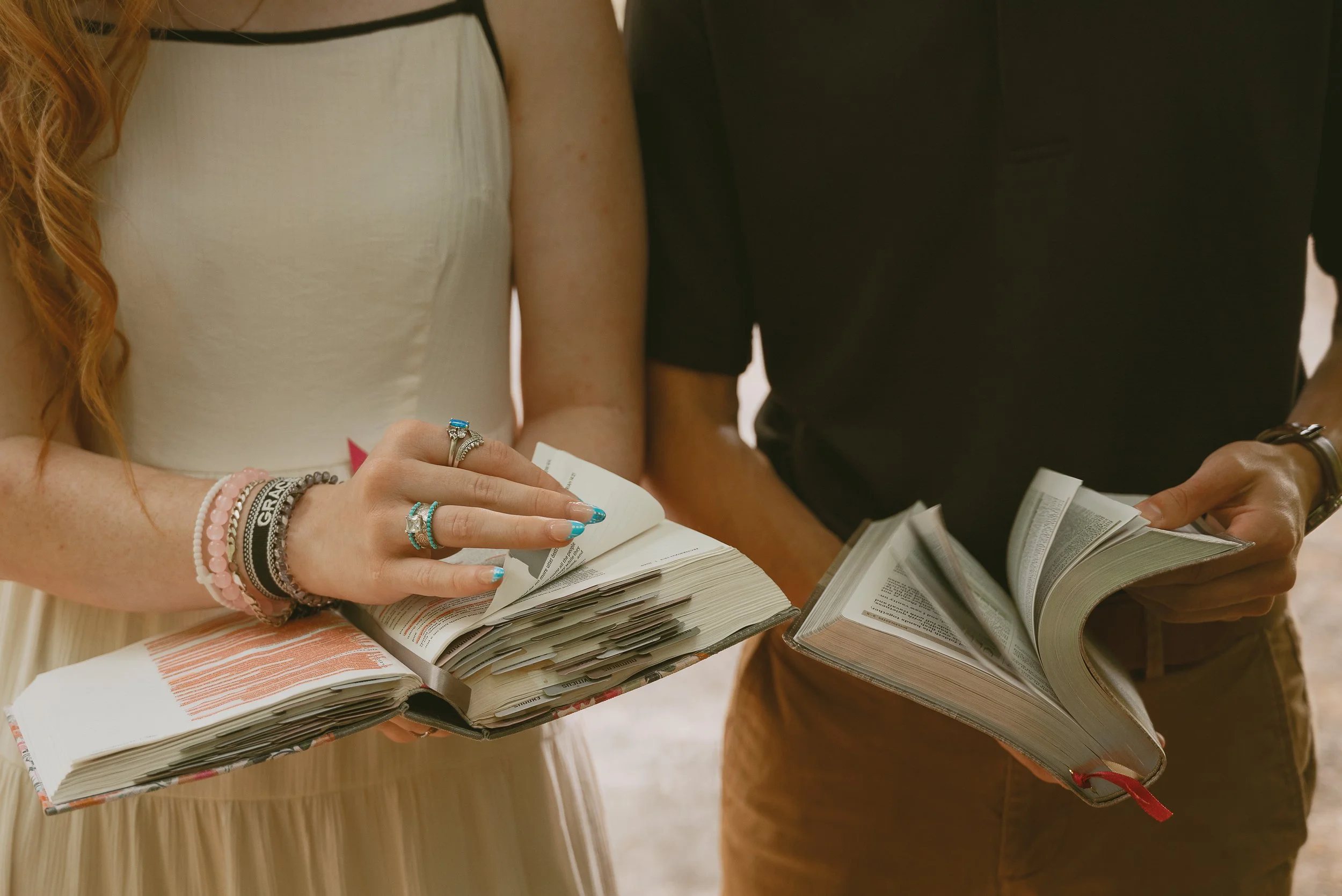 Close-up of multiple people holding and flipping through the pages of books or magazines.