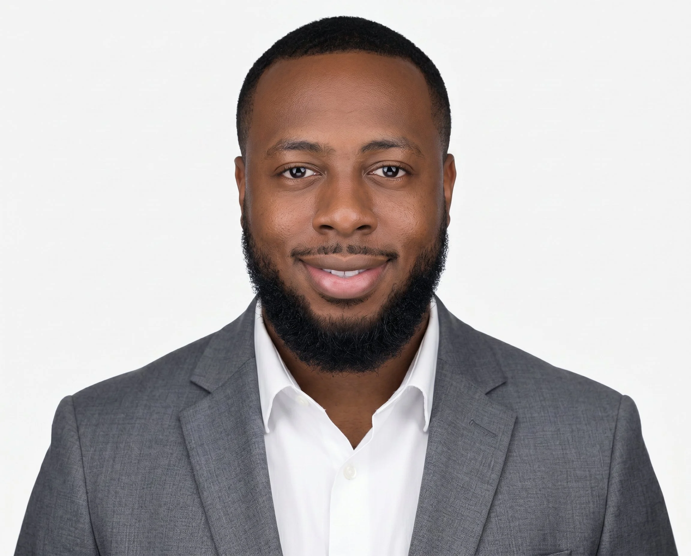 Close-up of a smiling African American man wearing a gray suit jacket and white shirt against a plain white background.