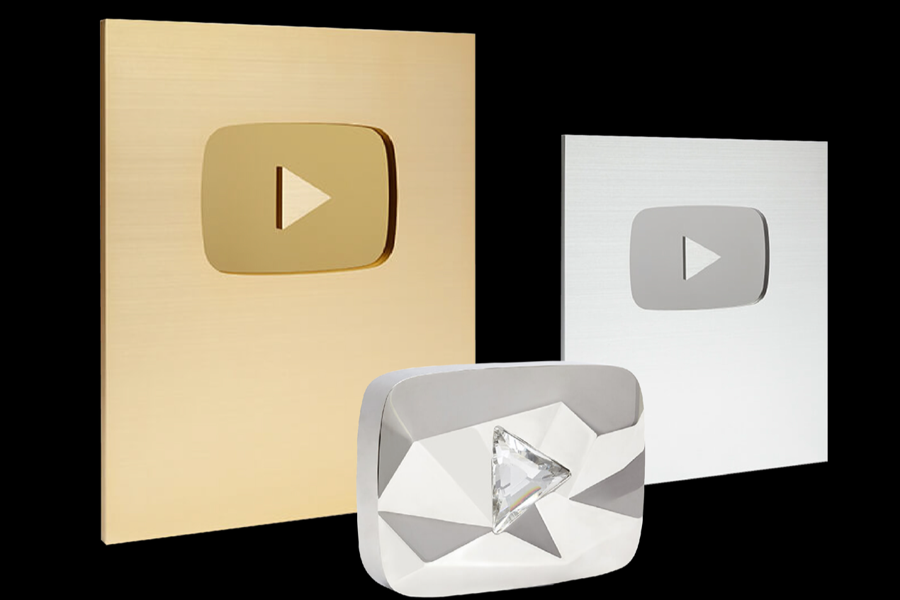 Three YouTube play button awards in gold, silver, and diamond designs arranged against a black background.
