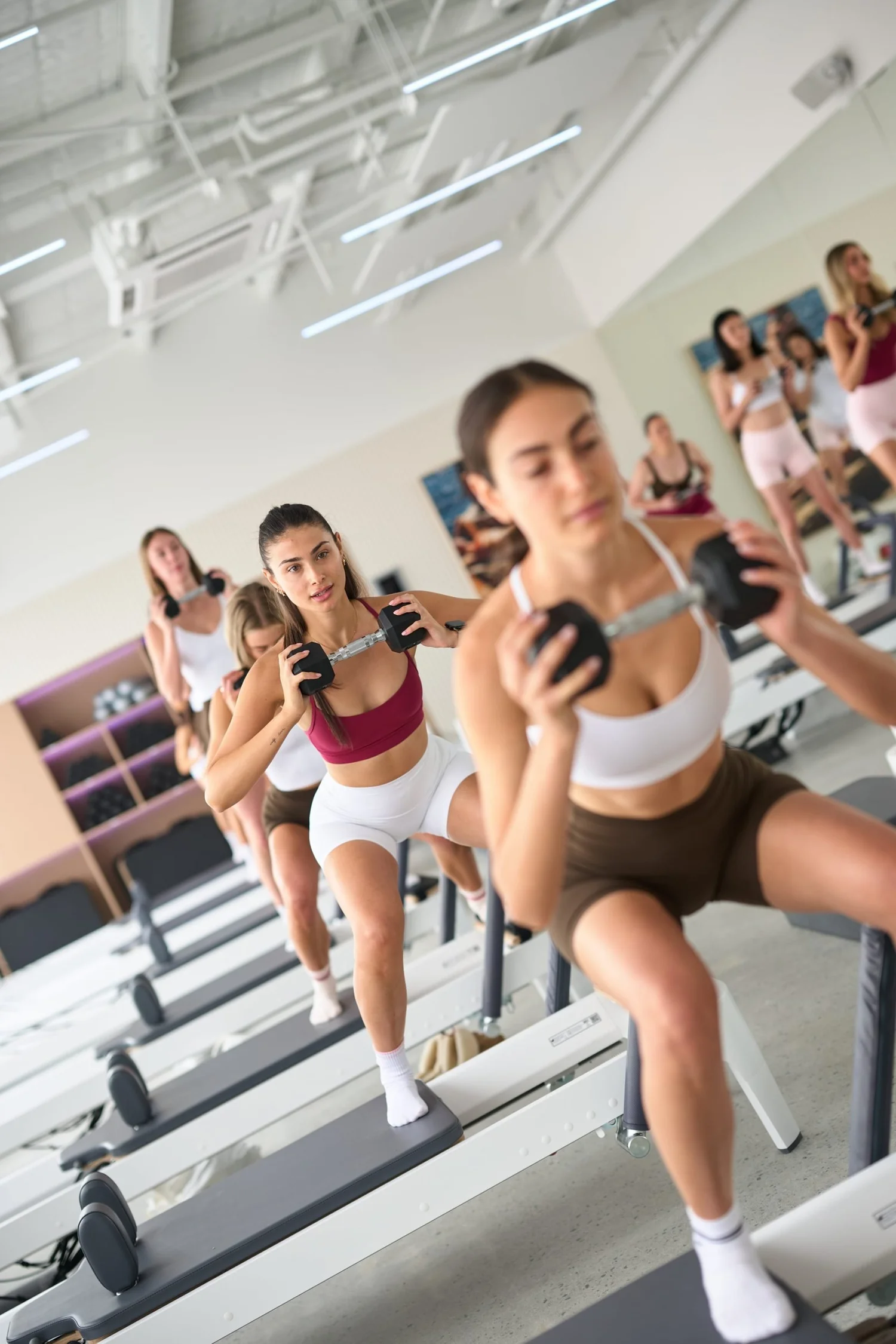 A member in a deep lunge on the reformer at Love Athletica