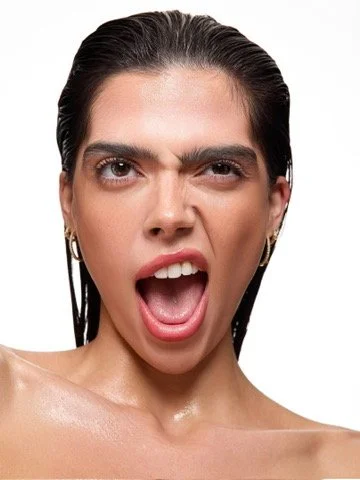 Editorial beauty portrait of a model with an open-mouth expression and wet, glowing skin, commercial makeup by Los Angeles artist Amber Rose.