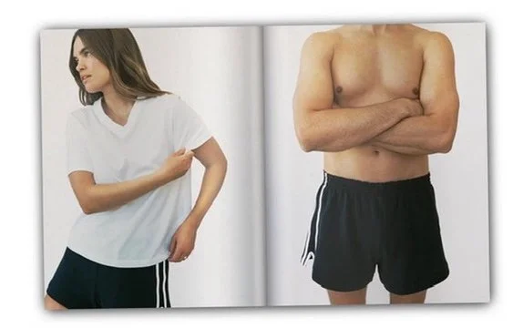 Side-by-side comparison of a woman in a white t-shirt and black shorts on the left, and a shirtless man in black shorts on the right, both standing against a plain white background. Hair and makeup by Amber Rose.