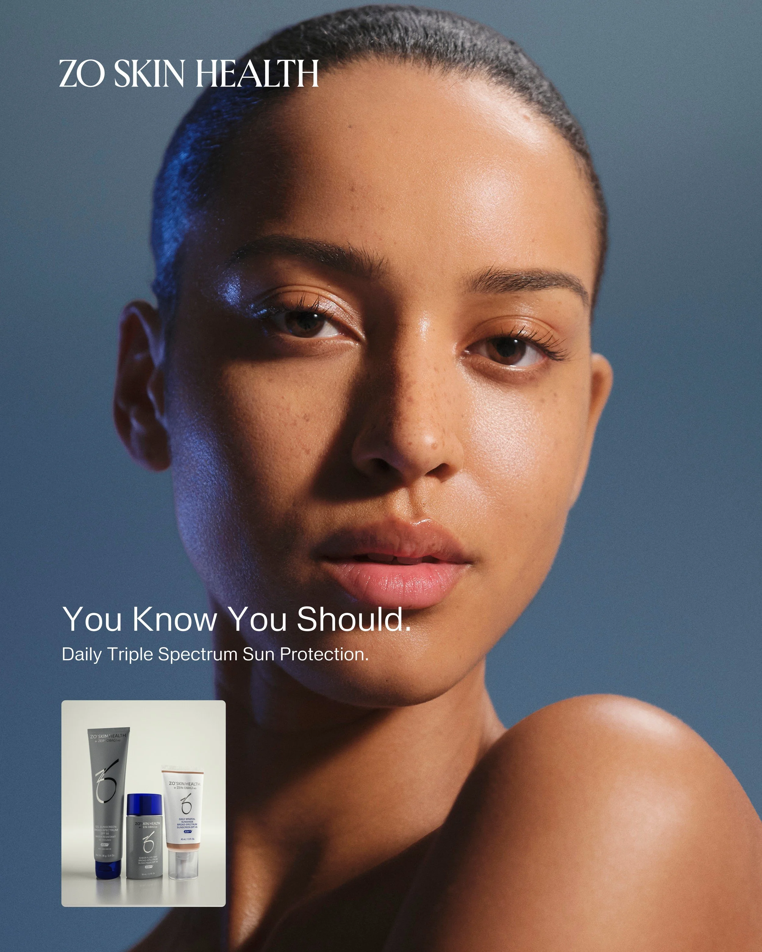 Model with radiant skin beside ZO Skin Health Sunshade sunscreen in cool blue light. Hair and makeup by Amber Rose.