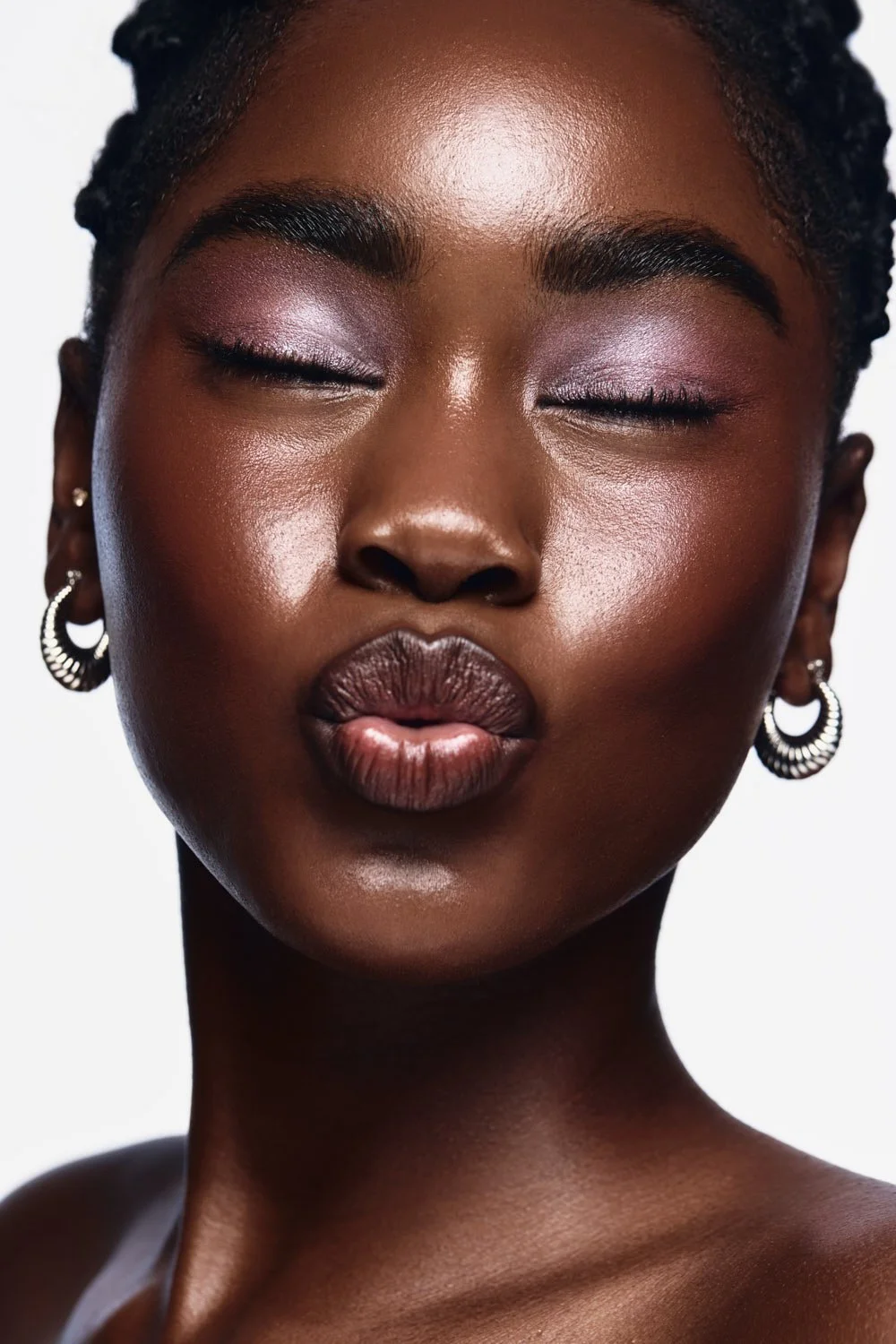 Radiant beauty portrait of a model with shimmery lavender eyeshadow and dewy highlighted skin, commercial makeup by Los Angeles artist Amber Rose.