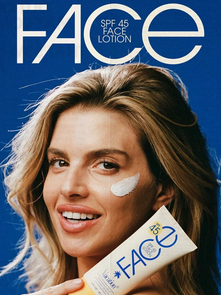 A woman applying face lotion with SPF 45 on her cheek, holding a tube of face lotion, with a large promotional poster behind her showing her face. Hair and makeup by Amber Rose.