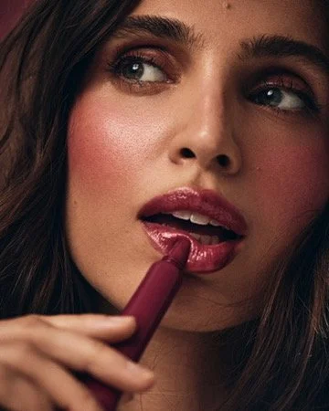 Close-up of a woman applying lipstick. Los Angeles premiere hair and makeup artist, Amber Rose.