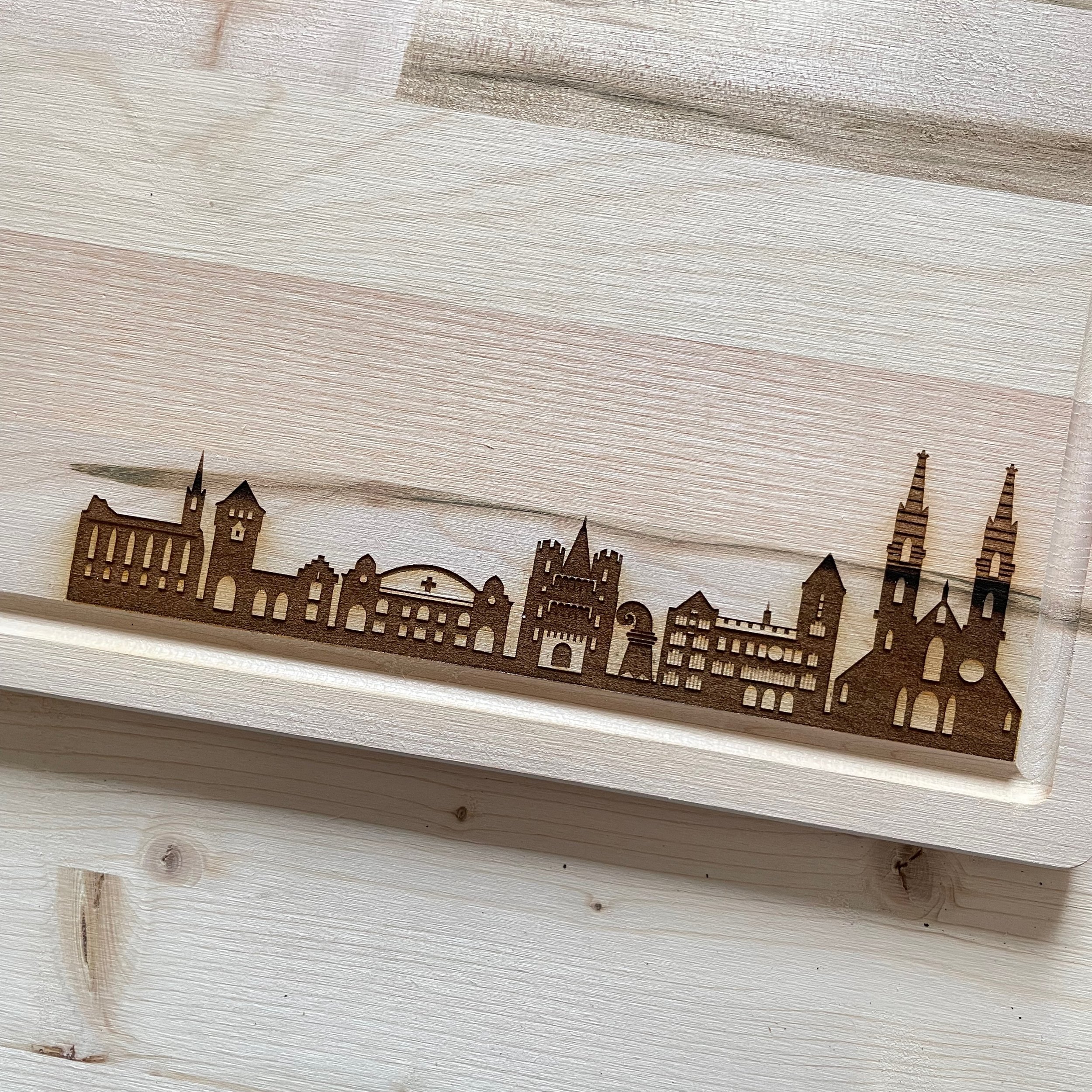 engraved beechwood cutting board with basel skyline and BASEL. Close up of skyline.