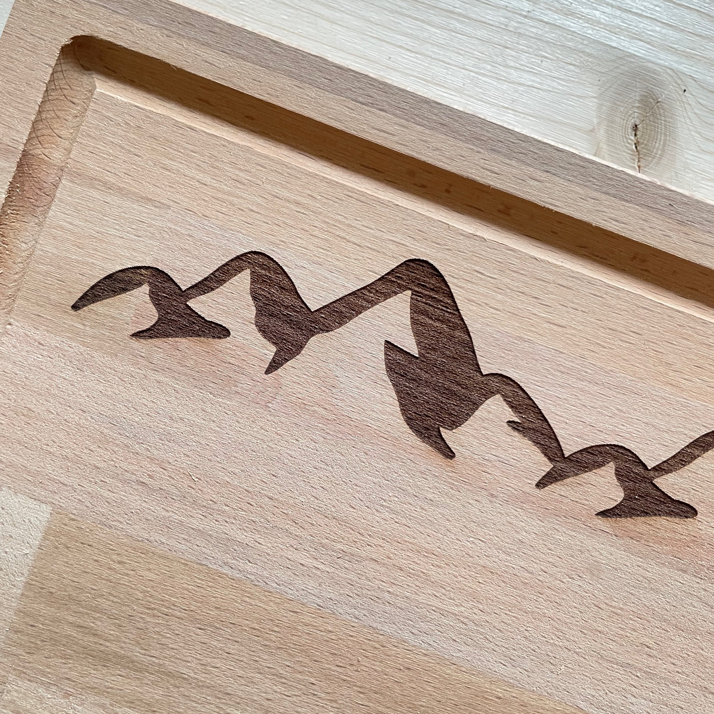 Beechwood cutting board Engraved with "Switzerland" and the iconic Swiss Alps. Close up of engraving.