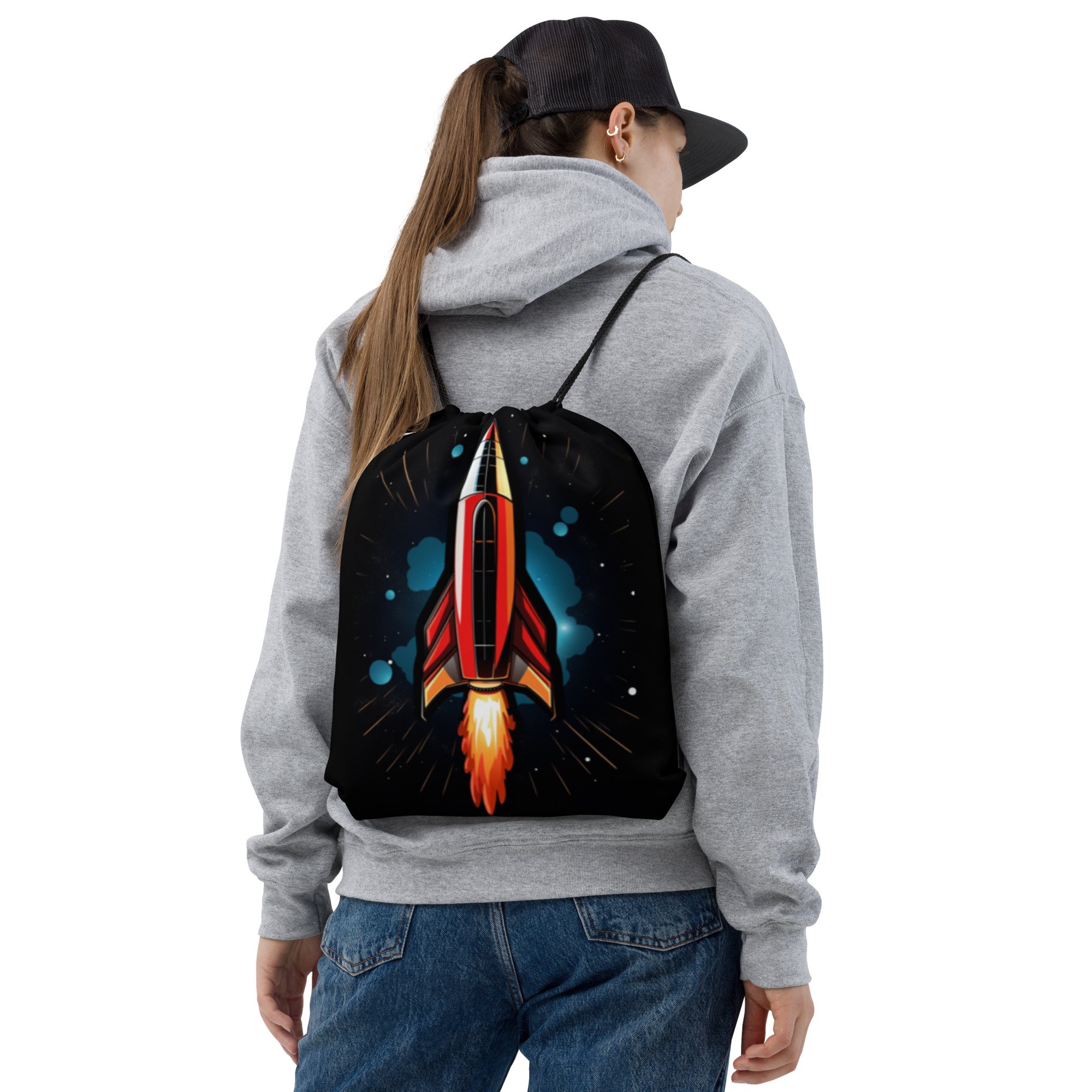 The red rocket ride drawstring back pack being worn on someones back using both straps.