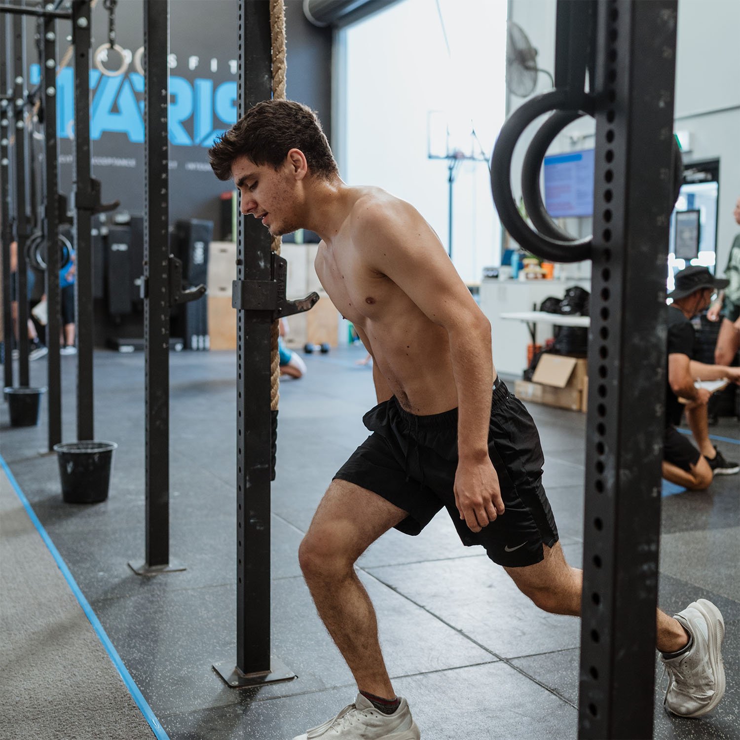 Male member mid-rep doing a walking lunge during a workout at CrossFit TARIS in Brisbane.