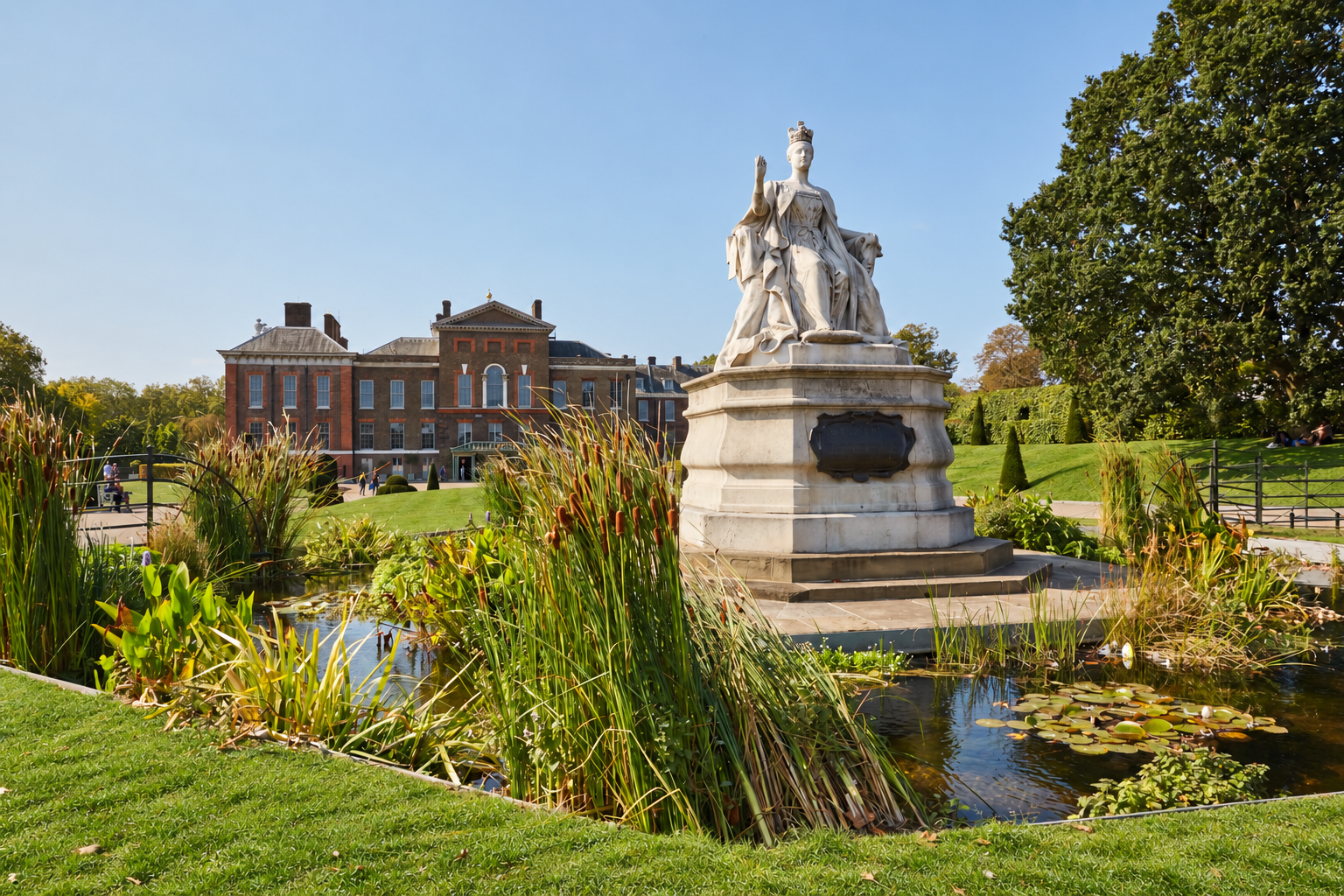 Kensington Palace and the Queen Victoria statue in Kensington Gardens, near Holland Park Gate, London