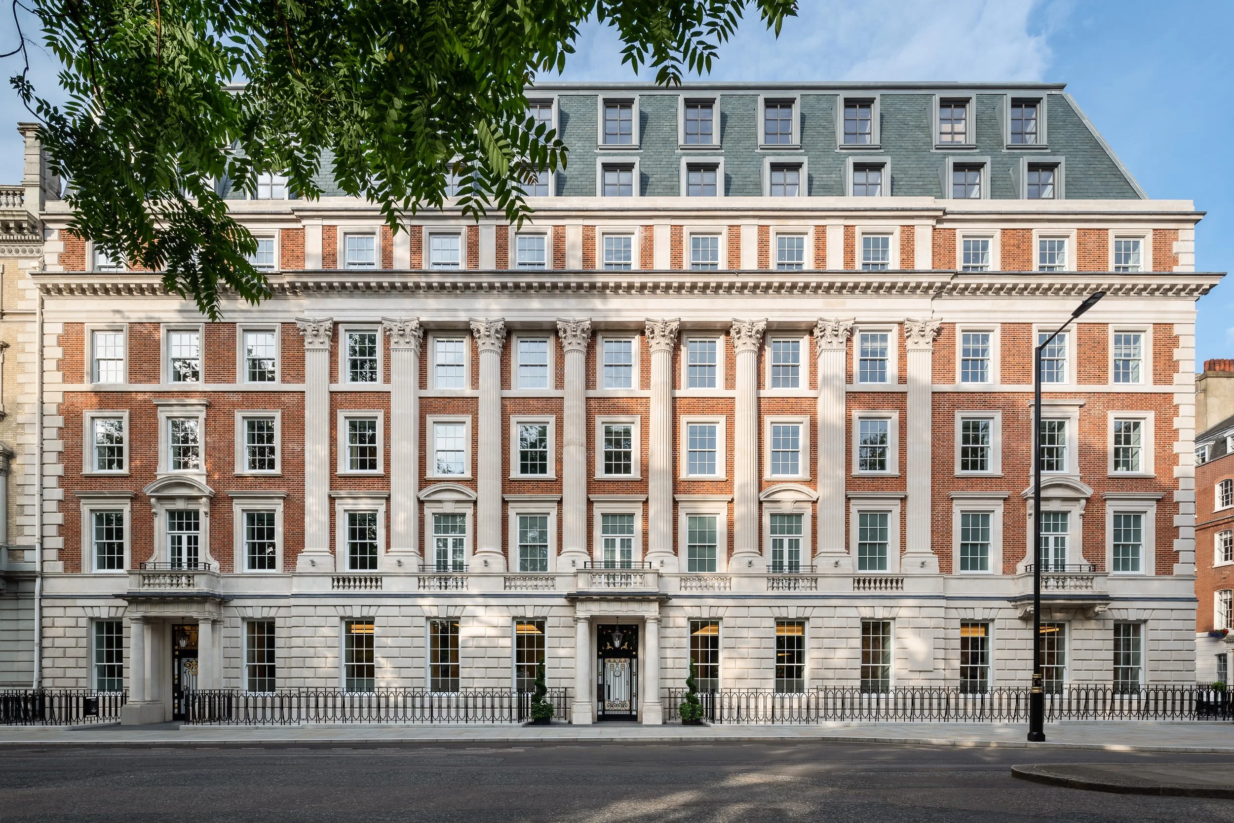 Red brick and stone facade with Corinthian columns at No.1 Grosvenor Square, a Lodha development in Mayfair, London
