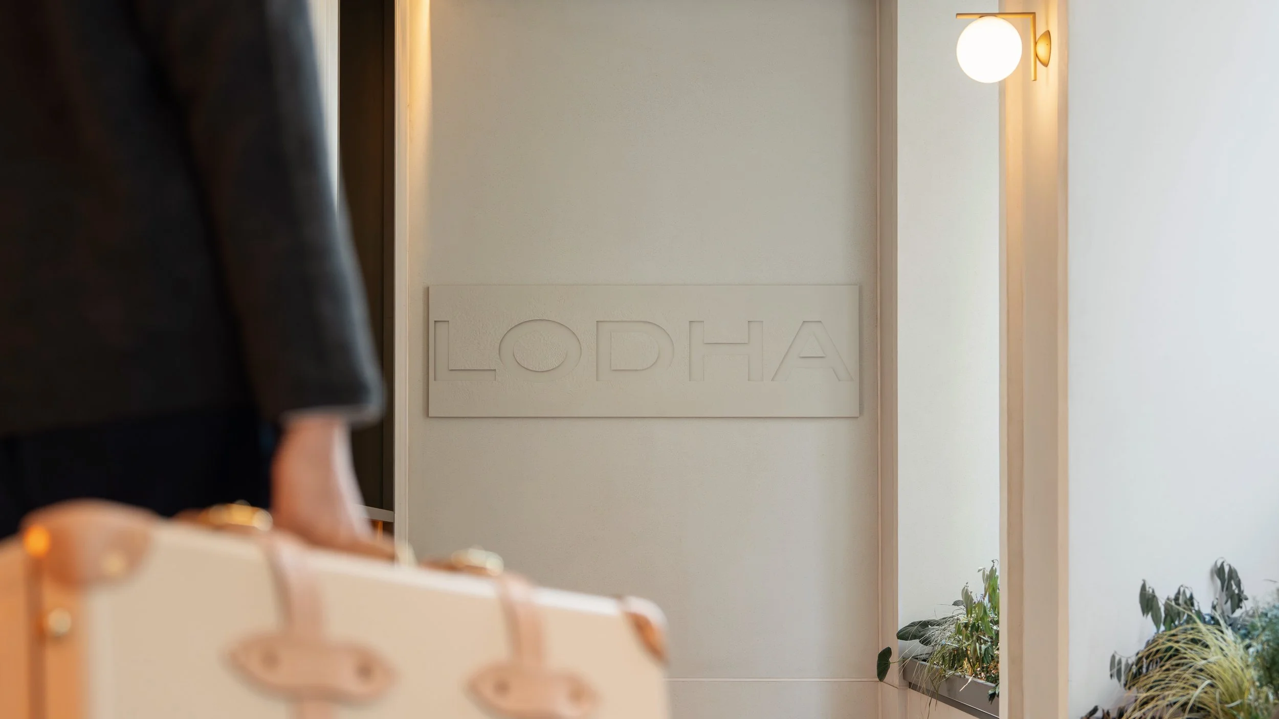 Concierge carrying luggage at the Lodha pedestrian entrance of Holland Park Gate, Kensington High Street, London