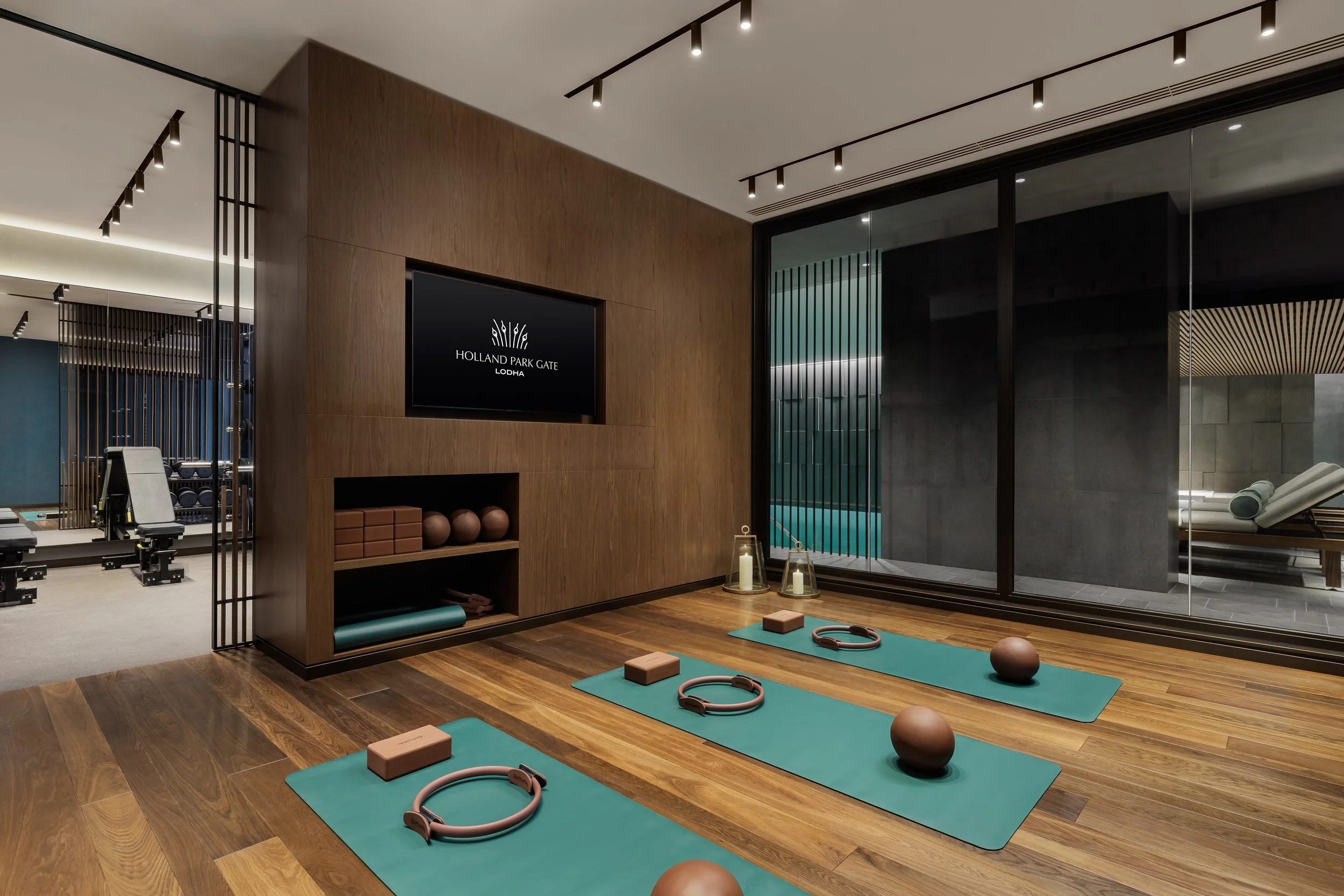 Residents' yoga and Pilates studio with mats and wall-mounted screen at Holland Park Gate, Kensington, London