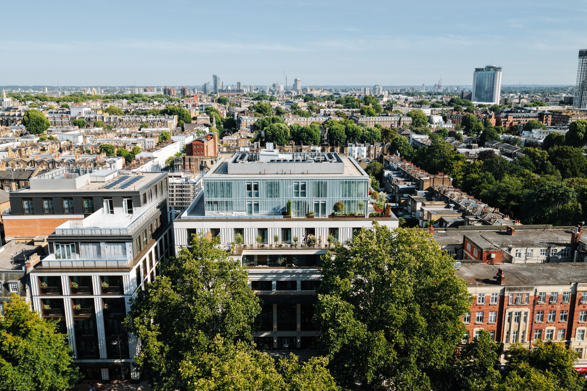 Aerial view of Holland Park Gate surrounded by tree-lined Kensington streets and the London skyline, W8