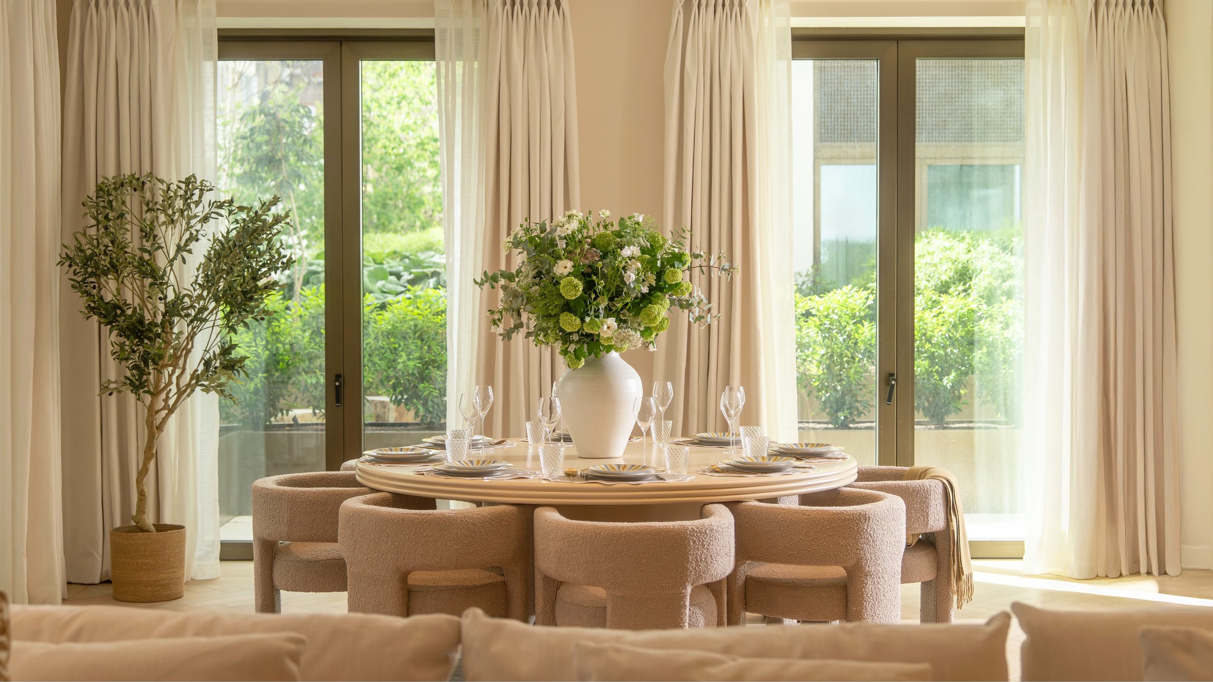 Elegant dining room with round table and garden views in a private residence at Holland Park Gate, Kensington, London