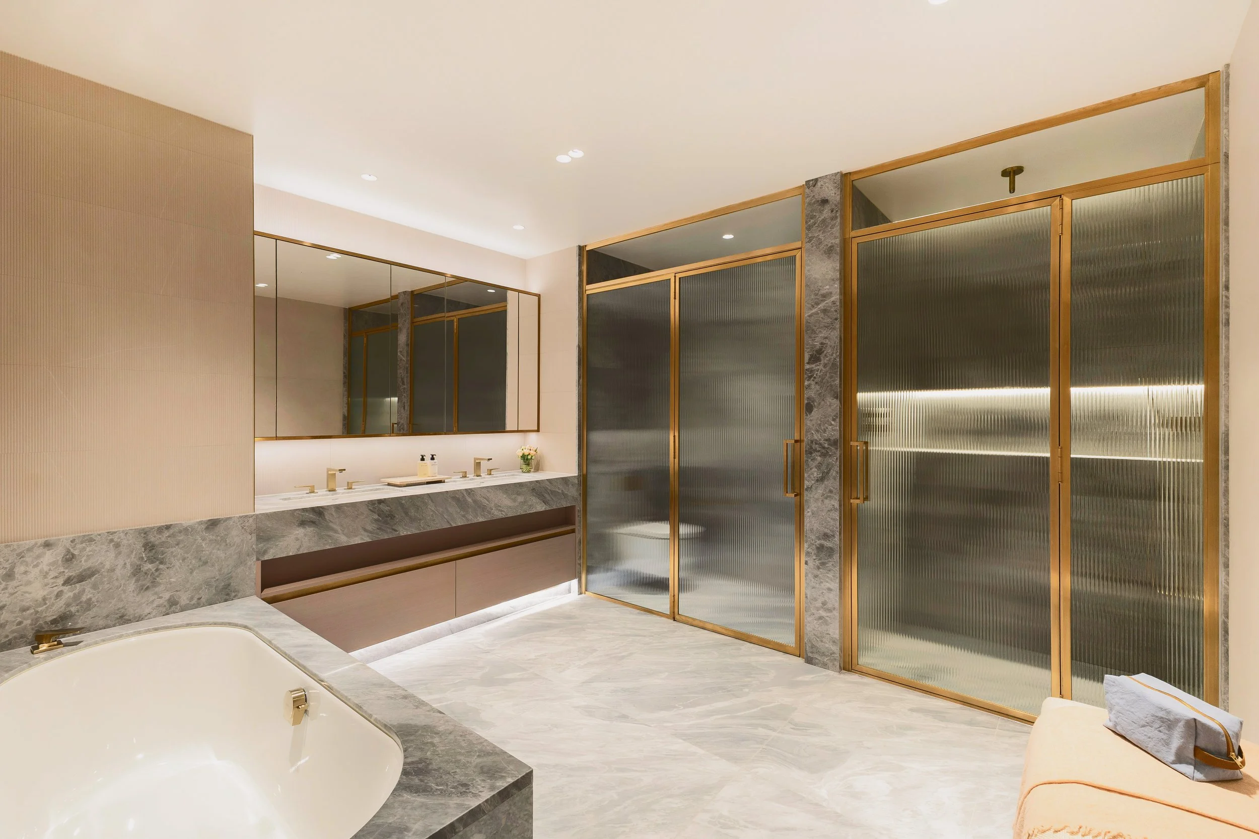 Marble bathroom with freestanding bath, double vanity and brass-framed shower in Residence 82 at Holland Park Gate, London