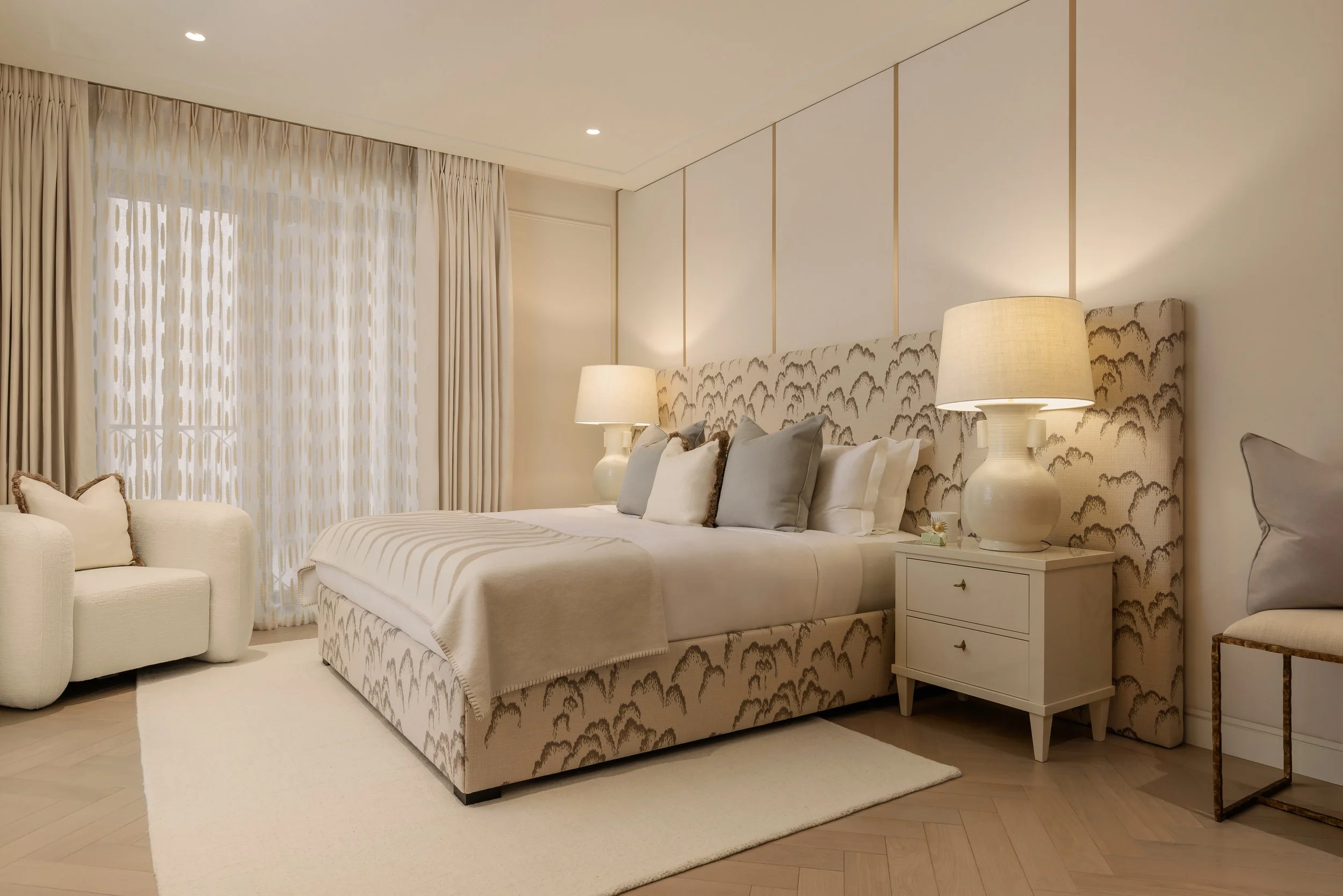 Bedroom with upholstered bed and bedside lamps in a three-bedroom apartment at Holland Park Gate, Kensington, London