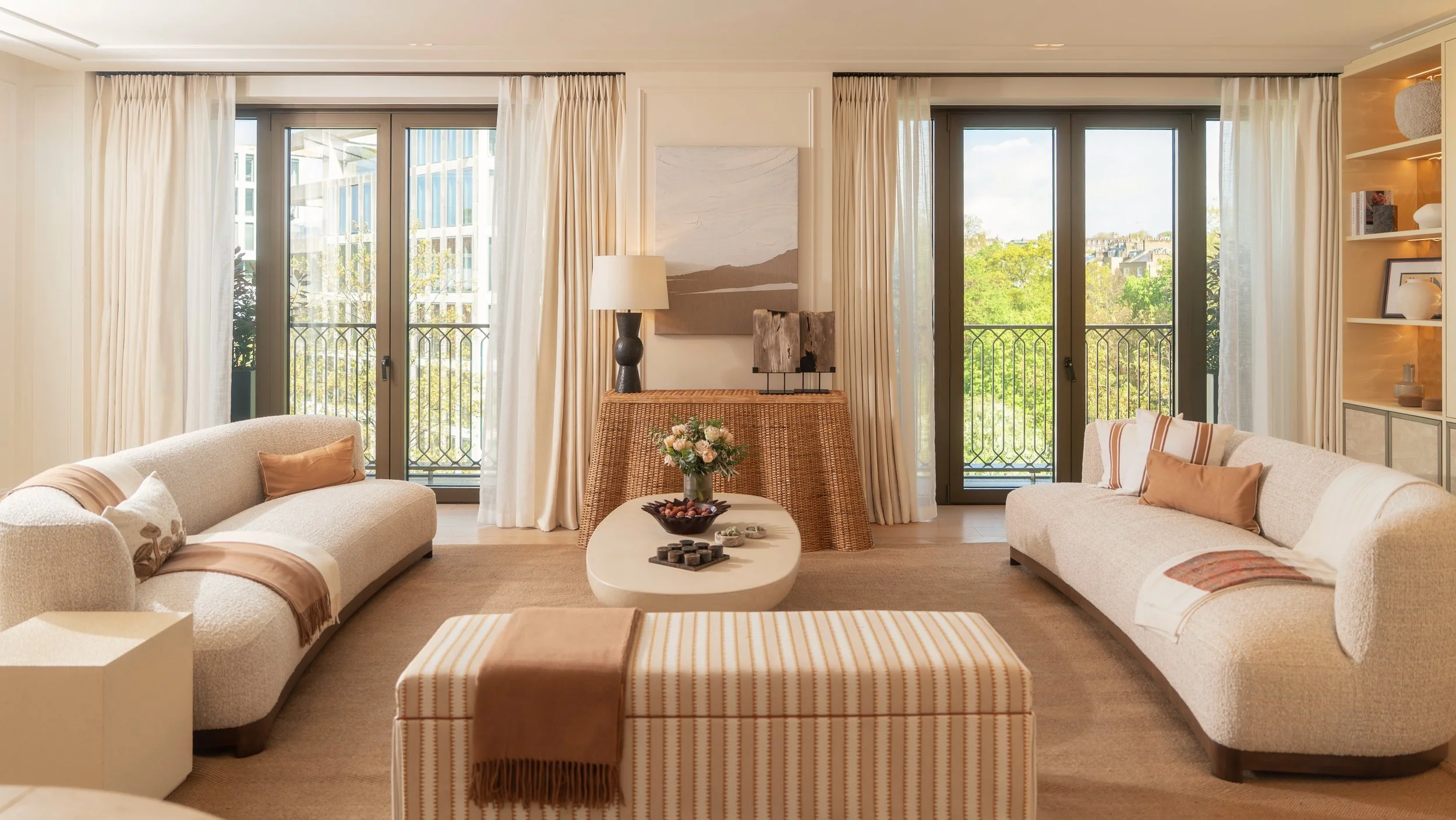 Move-in ready living room designed by Studio Lodha, with balconies overlooking treetops at Holland Park Gate, London