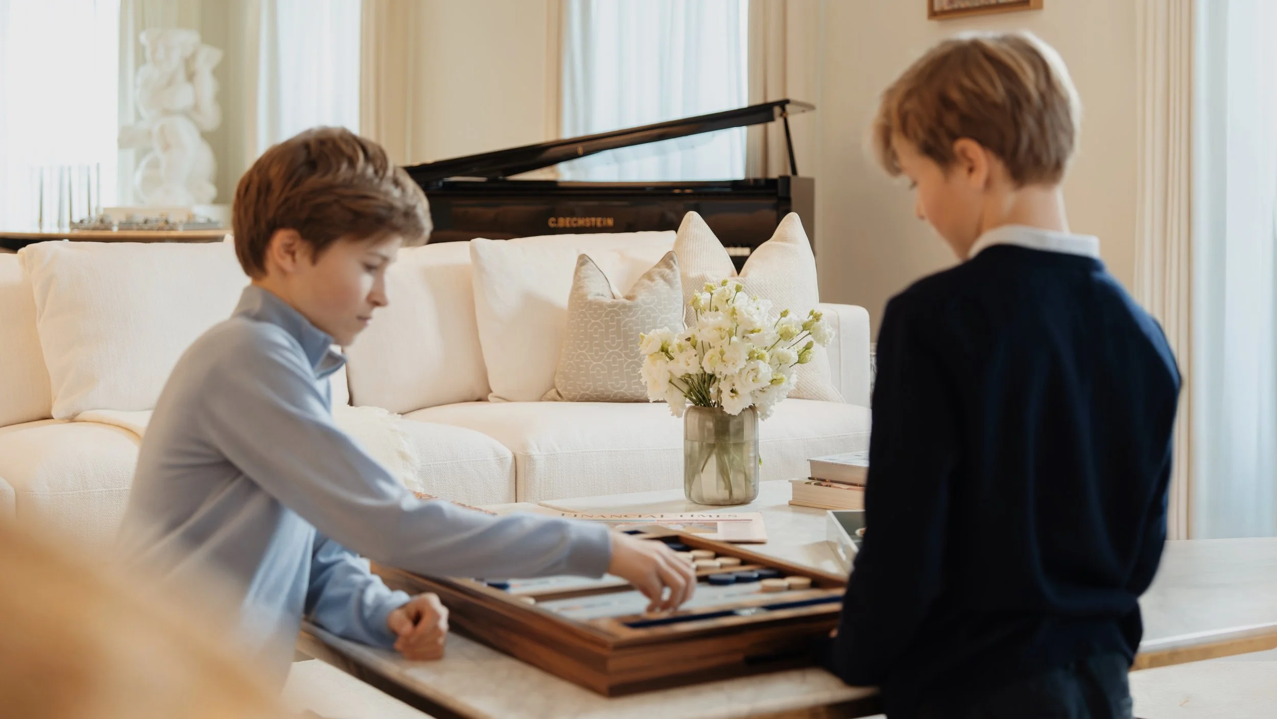 Children playing backgammon in the living room of a family residence at Holland Park Gate, Kensington, London