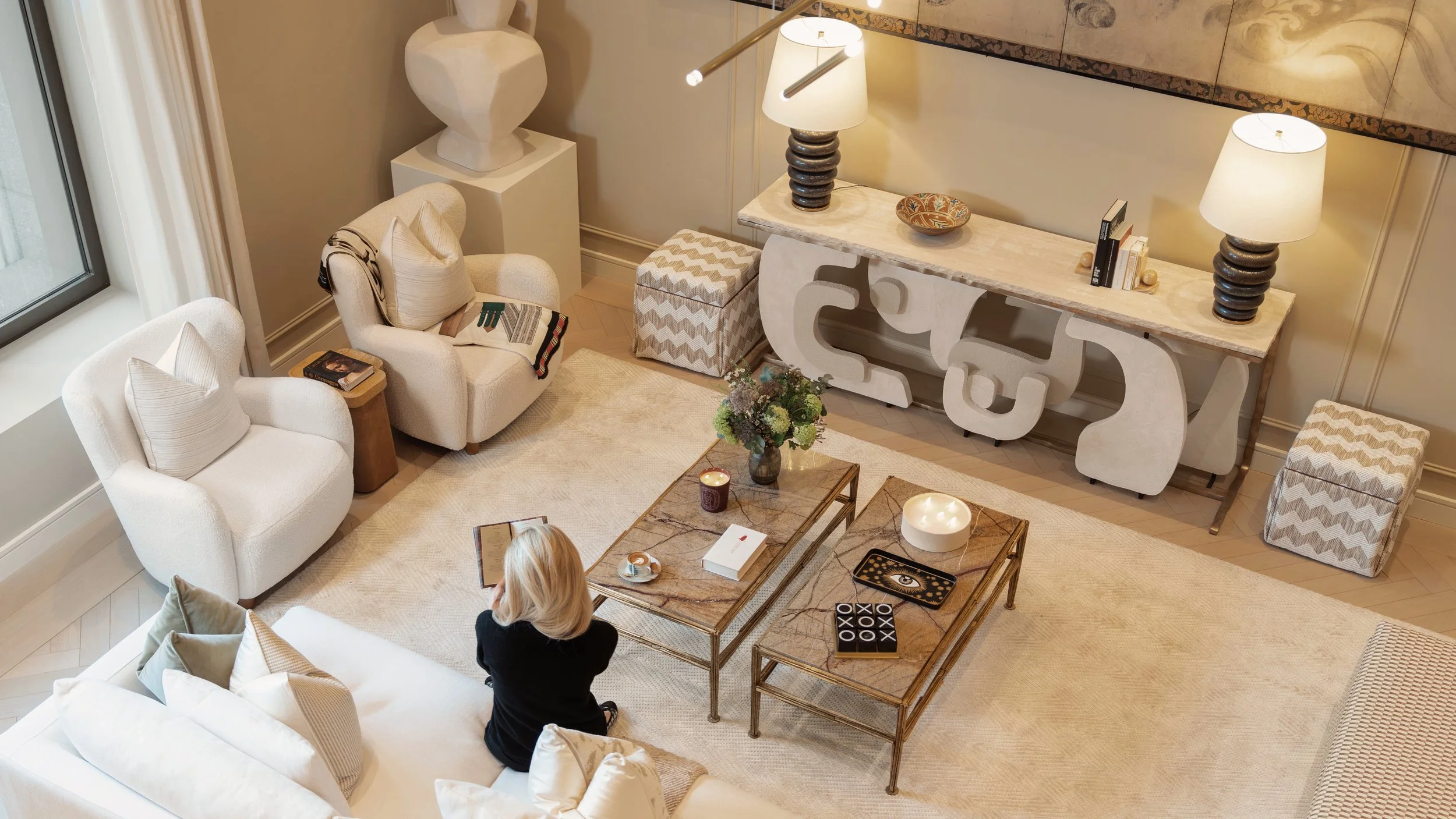 Overhead view of an elegant drawing room with sculptural console and marble coffee tables in a Holland Park Gate residence, London