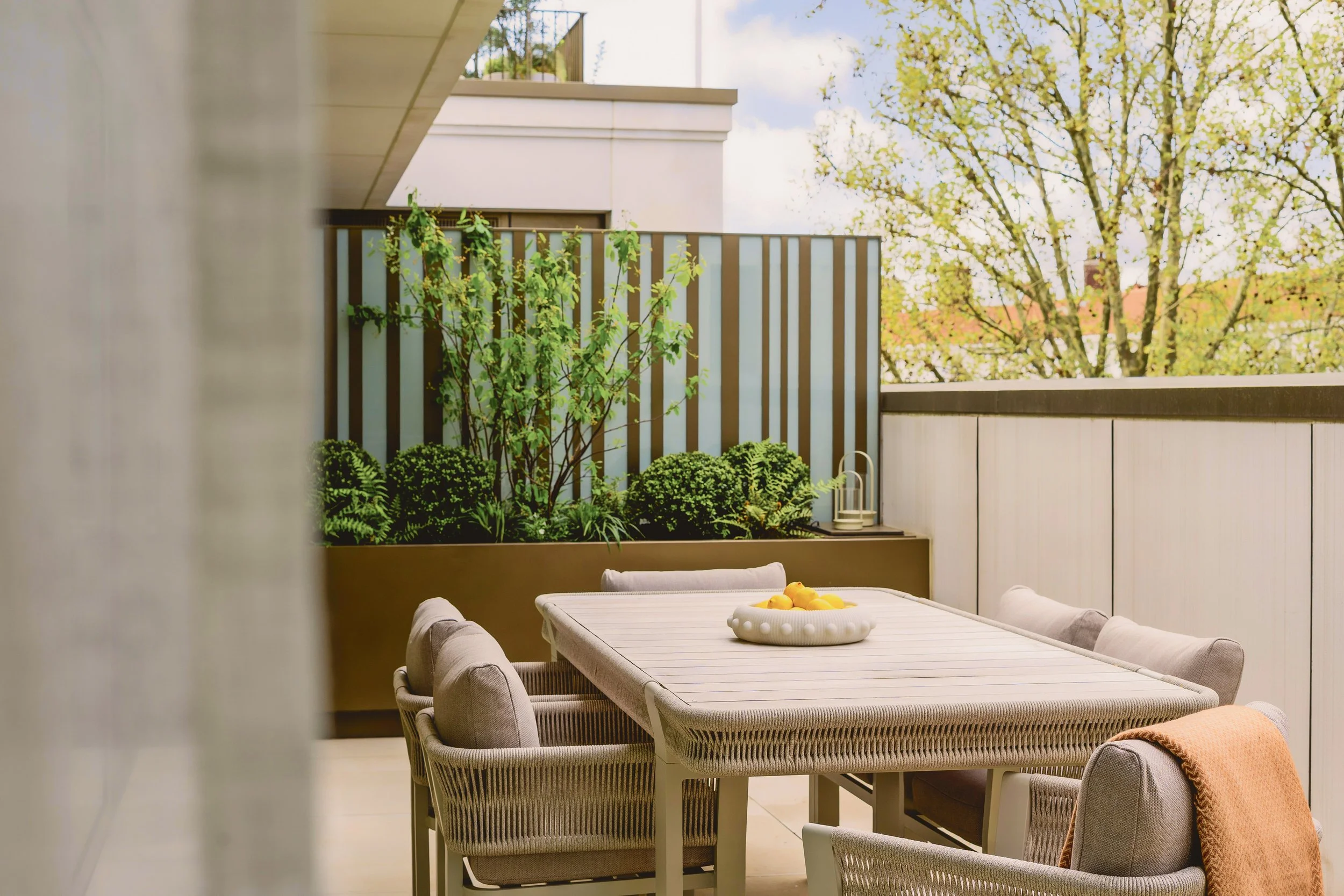 Private terrace with outdoor dining table and planting in Residence 82 at Holland Park Gate, Kensington, London