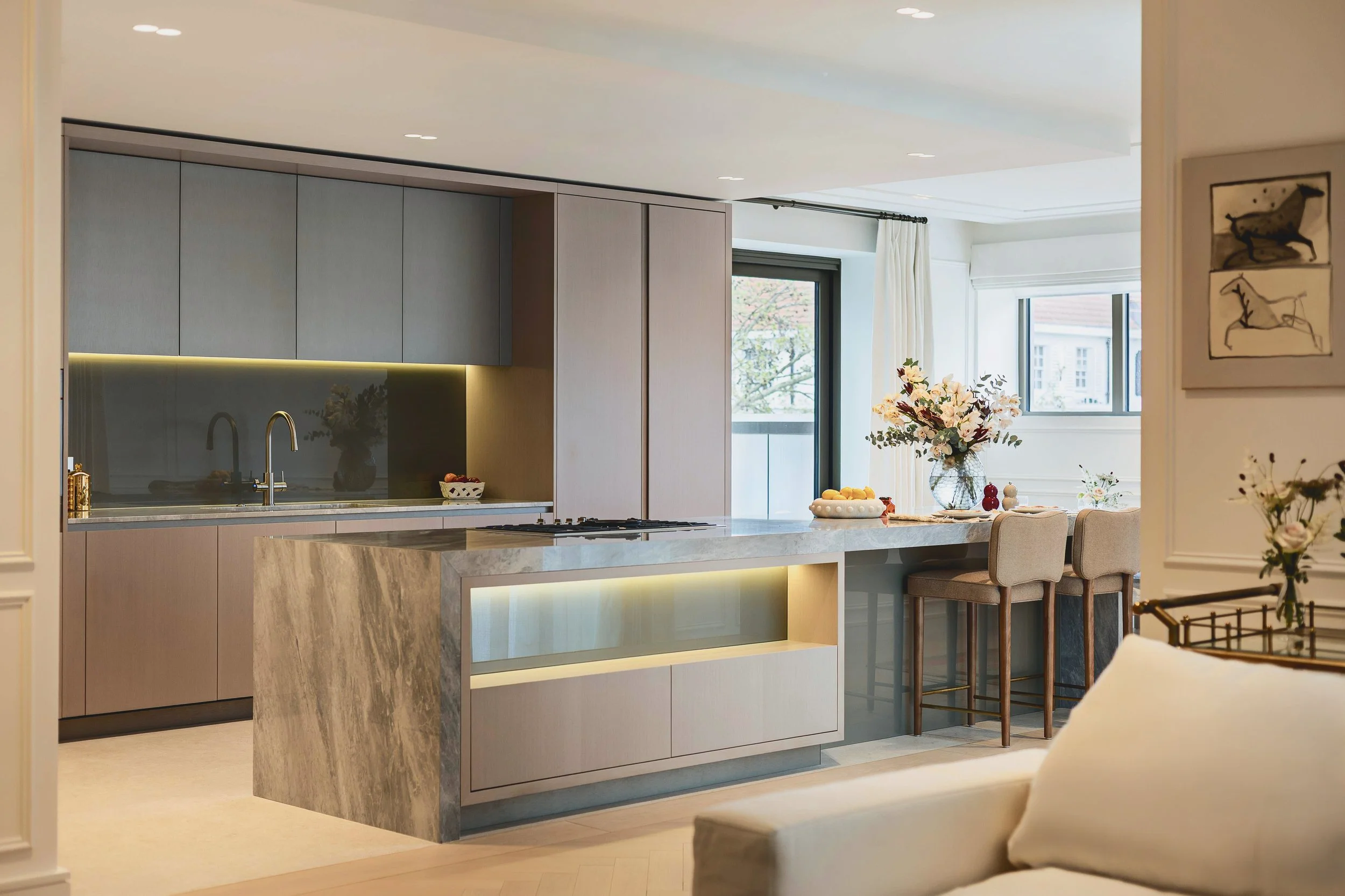 Bespoke kitchen with marble island and breakfast bar seating in Residence 82 at Holland Park Gate, Kensington, London