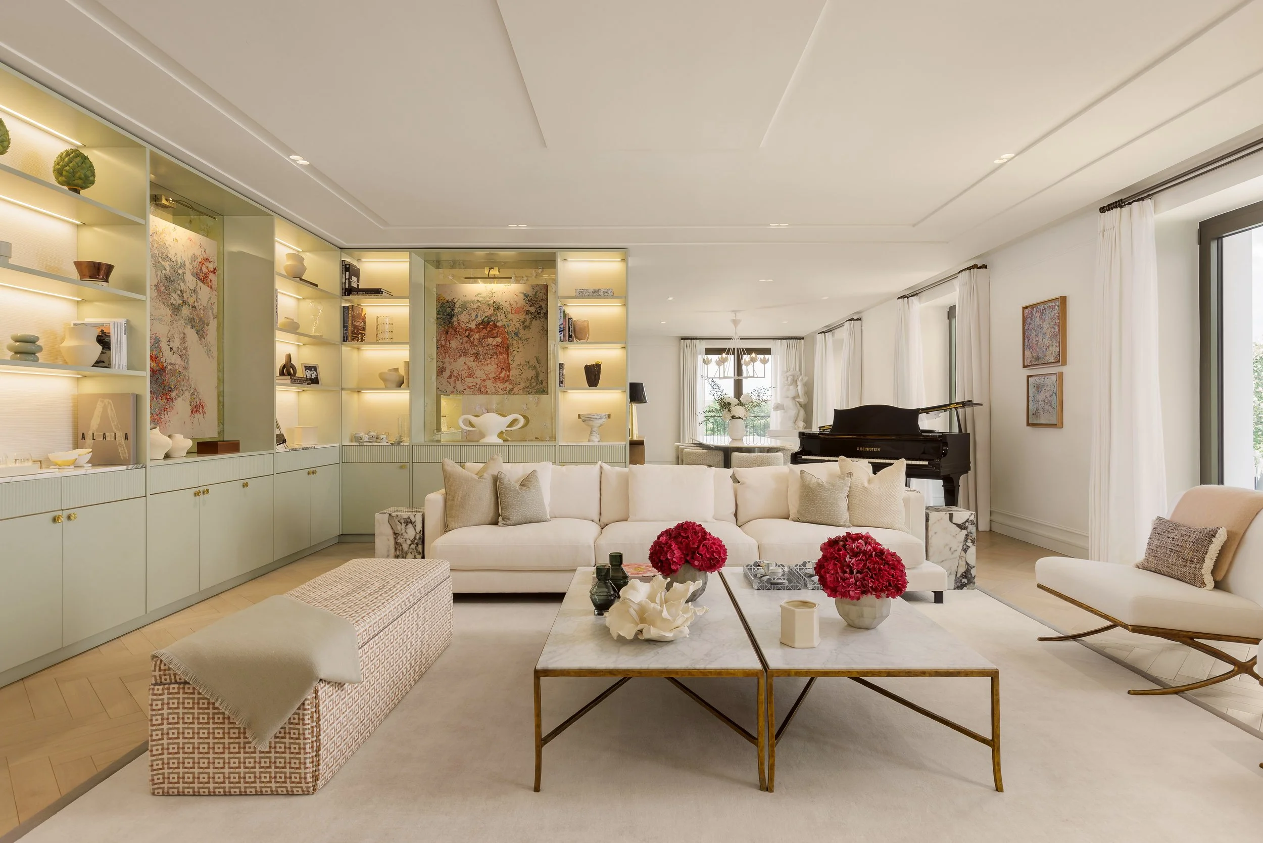 Spacious living room with grand piano and lit shelving in a four-bedroom apartment at Holland Park Gate, Kensington, London