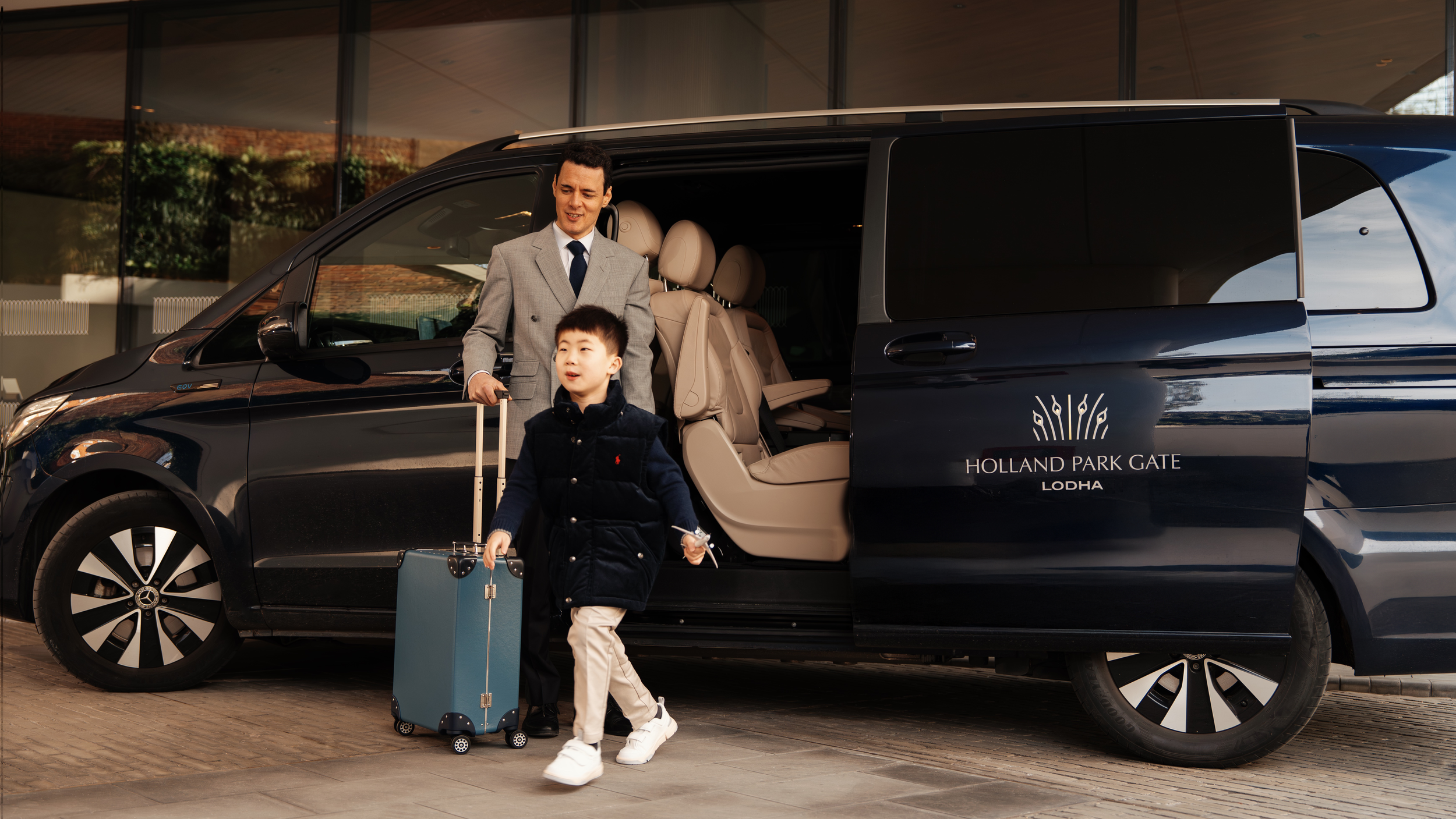 Chauffeur welcoming a young resident from the Holland Park Gate branded house car service, Kensington, London