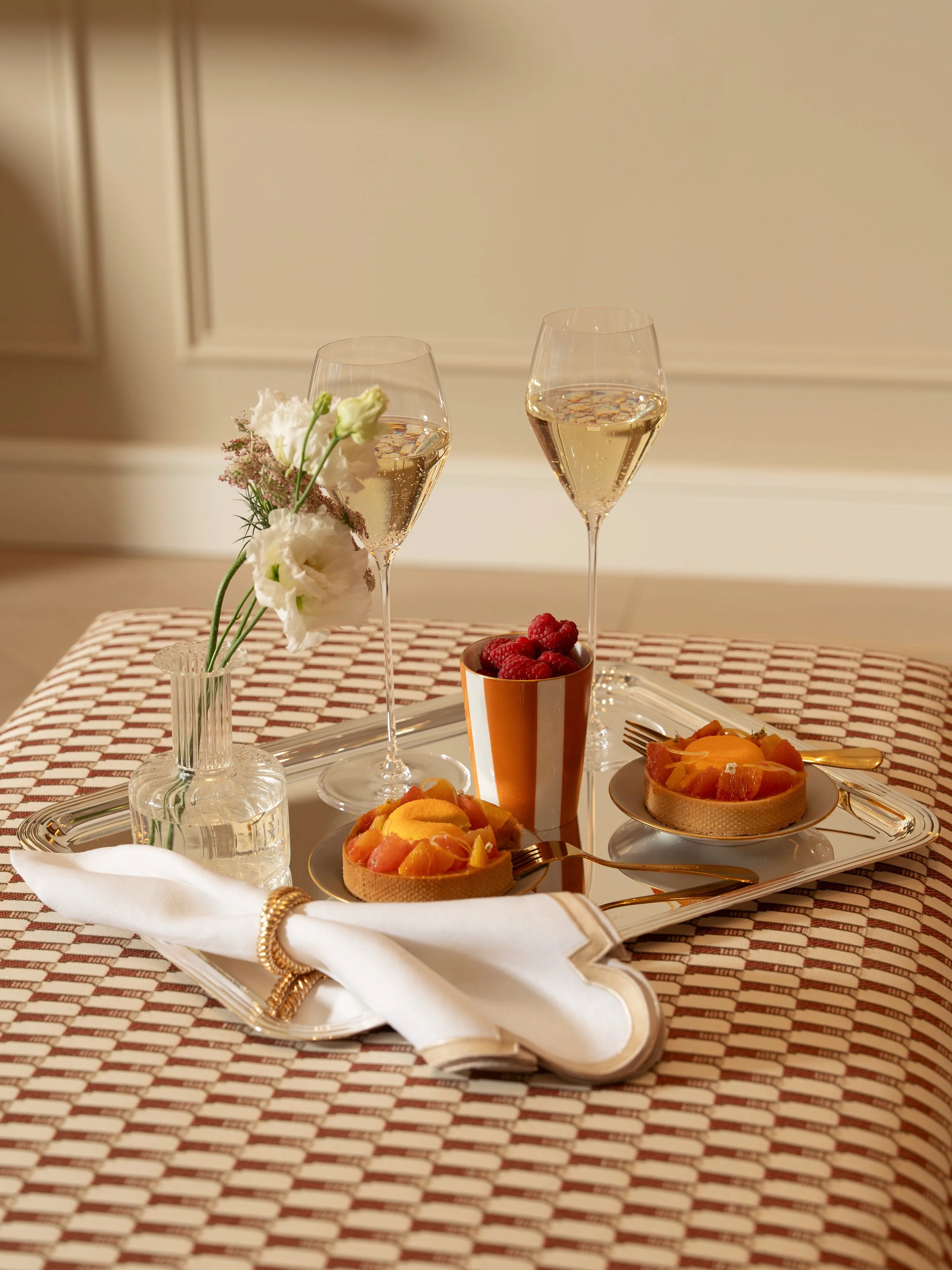 Champagne, citrus tarts and raspberries served on a silver tray by the in-residence dining service at Holland Park Gate, London