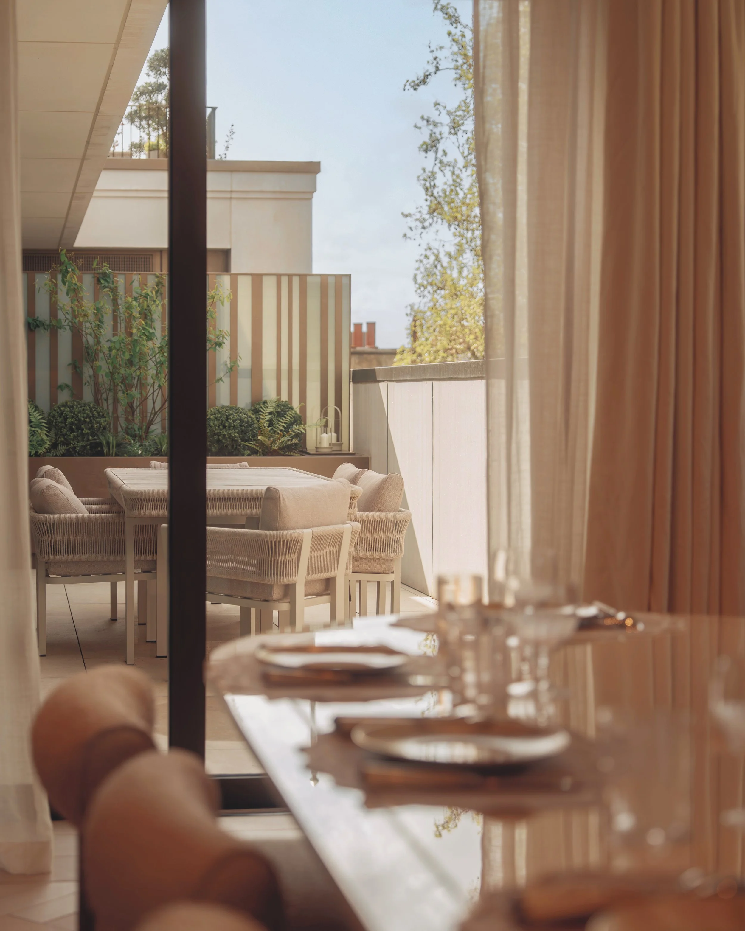 View from the dining room through glass doors to the private terrace in Residence 82 at Holland Park Gate, Kensington, London