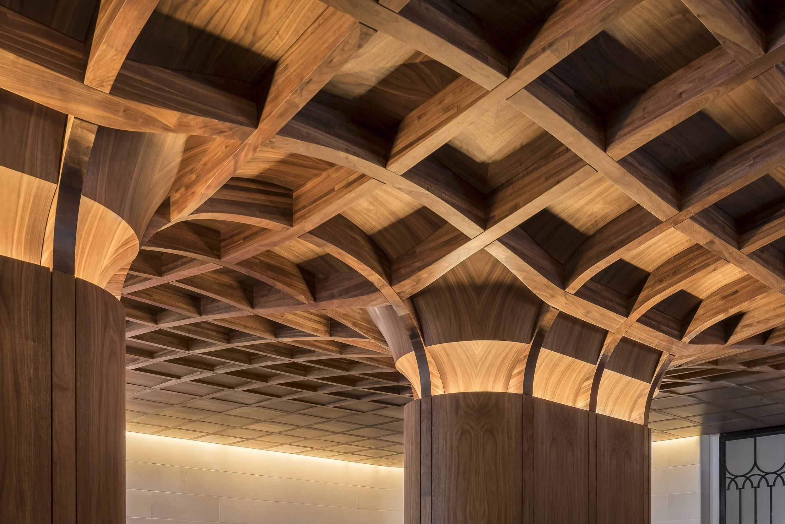 Sculpted timber columns and vaulted lattice ceiling in the arrival court at No.1 Grosvenor Square, Lodha, Mayfair, London
