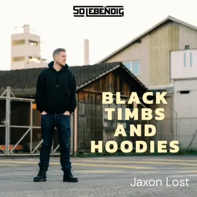 Der Albumtitel 'Black Timbms and Hoodies' von Jaxon Lost ist auf dem Titelbild zu sehen, das einen Mann in schwarzer Hoodie, Jeans und Stiefeln auf einer Straße vor Gebäuden zeigt.