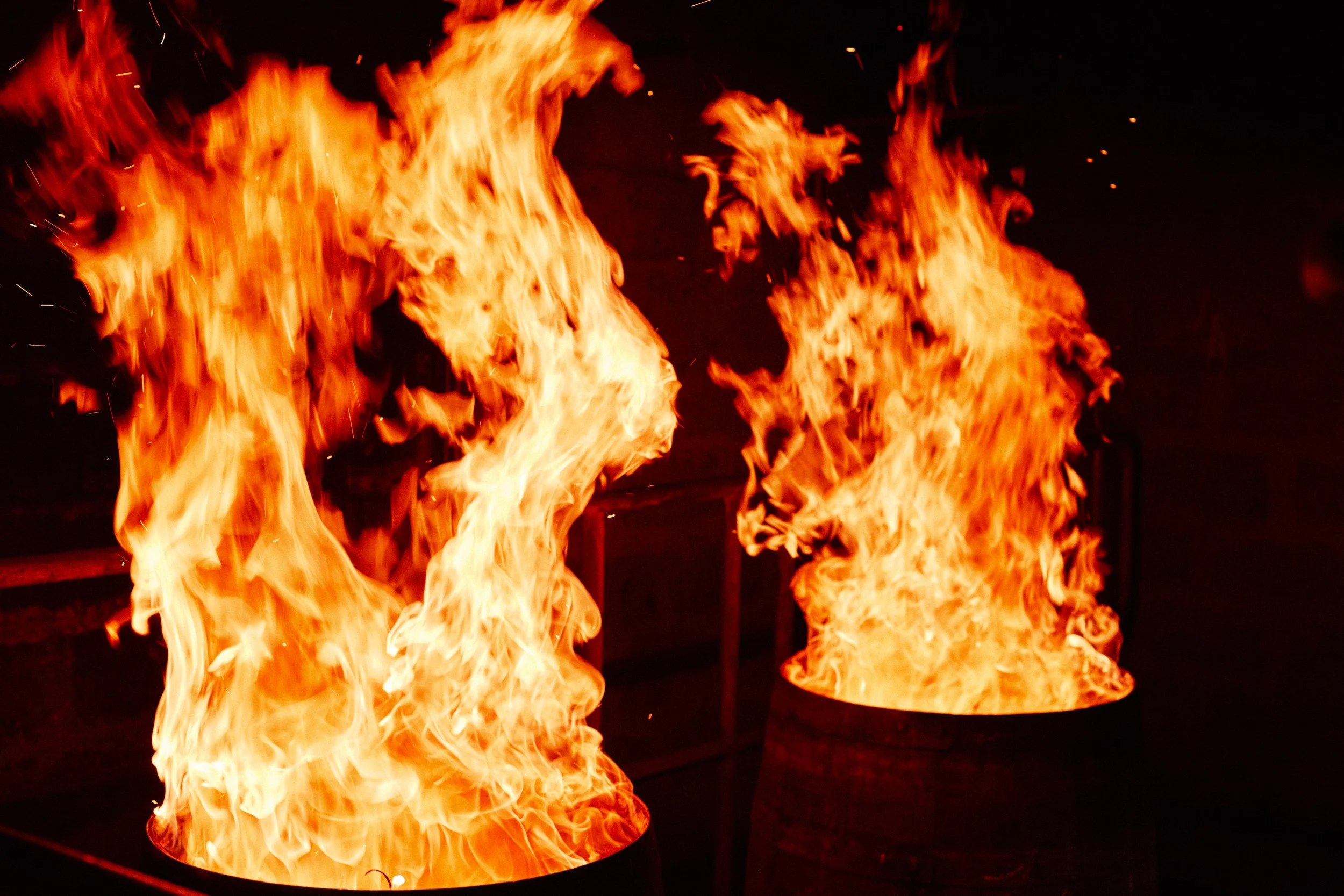  Casks being recharred: Barrels have their ends removed, the old charcoal flailed off, and are set alight over a gas burner. The heat toasts the fresh oak, transforming the lignins and tannins into complex flavour compounds; the new char helps to rem