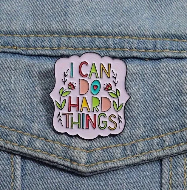 A colourful enamel pin that reads "I CAN DO HARD THINGS" on a denim fabric background. Mental Health (Anchored Thoughts)