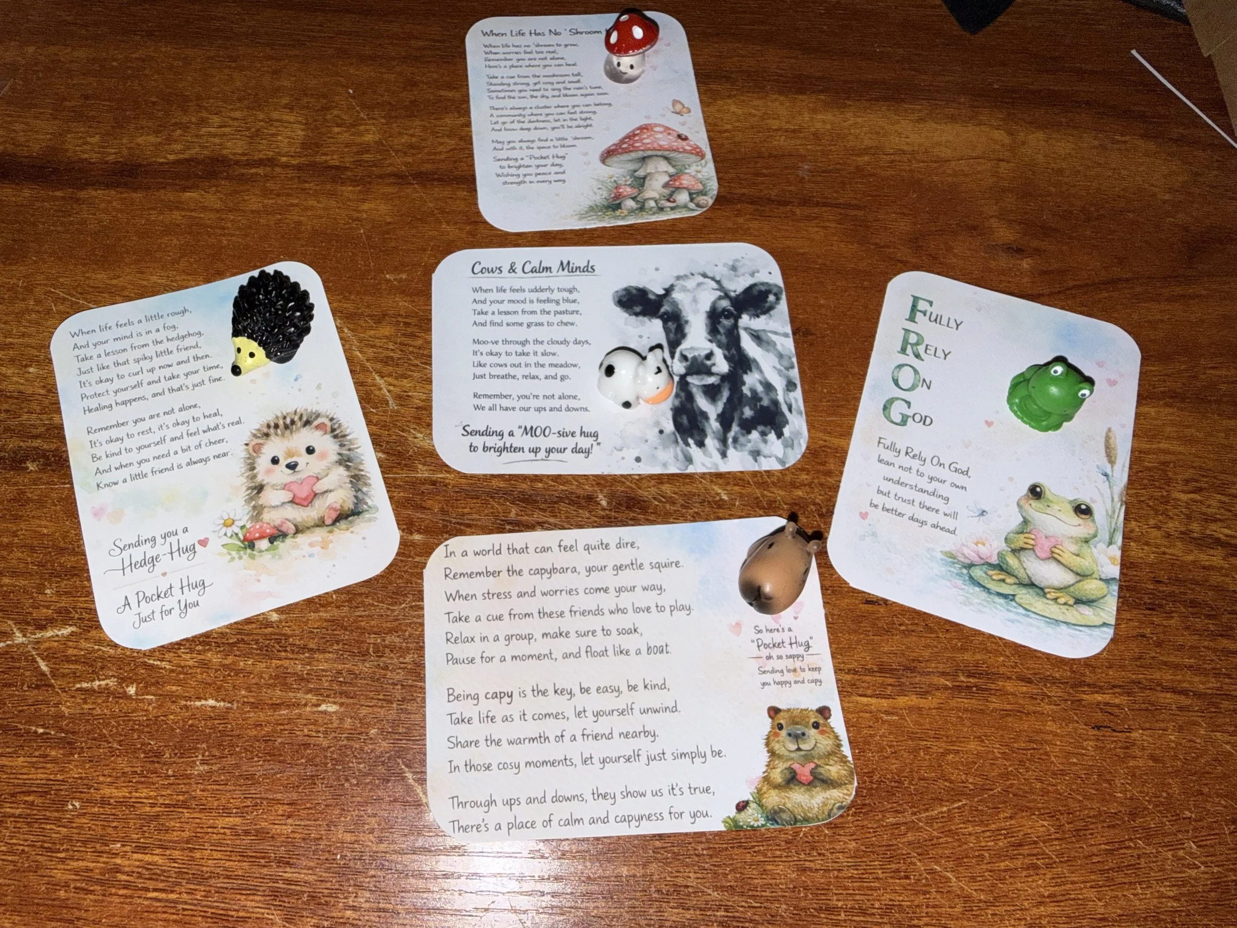 Collection of colorful cards with illustrations and poems about animals and finding calm, featuring mushrooms, hedgehog, cow, frog, and other animals. Mental Health (Anchored Thoughts) pocket hugs