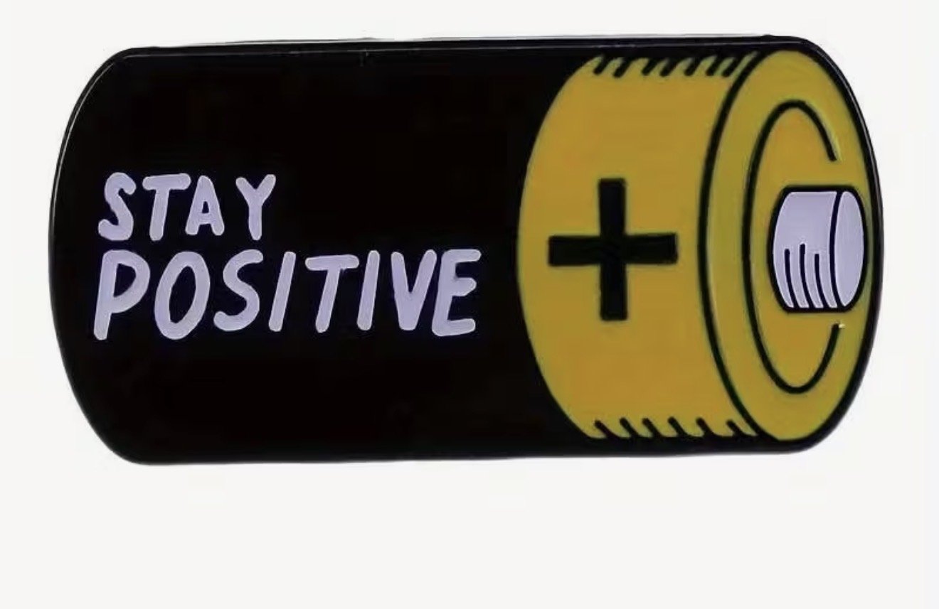 A black battery, the words 'Stay Positive' written on it. Mental health Anchored Thoughts