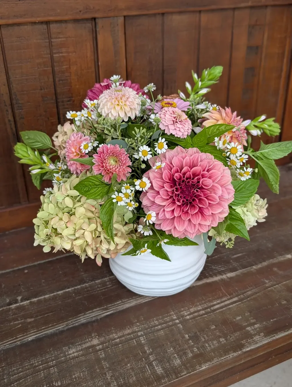 Breemar Flower Farm anniversary arrangement with coral peonies and orange poppies in a white ceramic vase, Ashland VA.