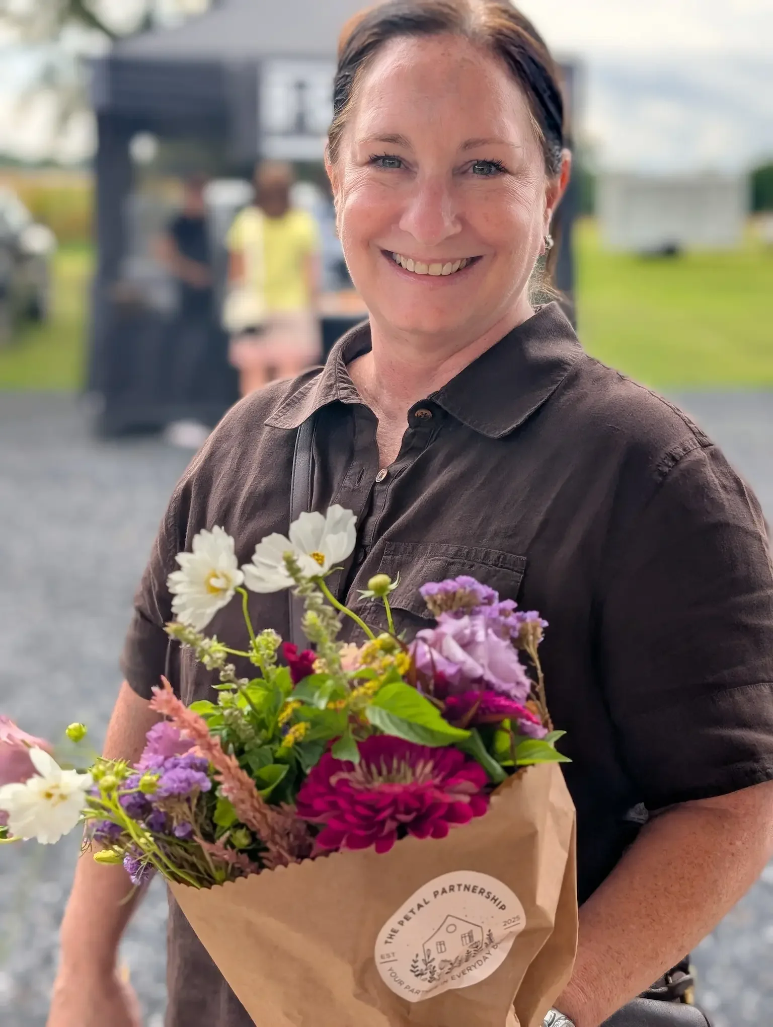 Happy customer from Hanover, VA, holding a fresh, seasonal flower bouquet purchased from Breemar Flower Farm, an Ashland florist.