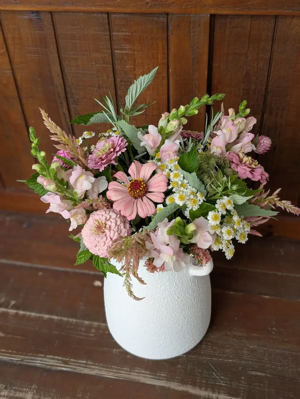 Breemar Flower Farm new baby arrangement in a light blue textured ceramic vase with soft pink peonies and sweet peas.