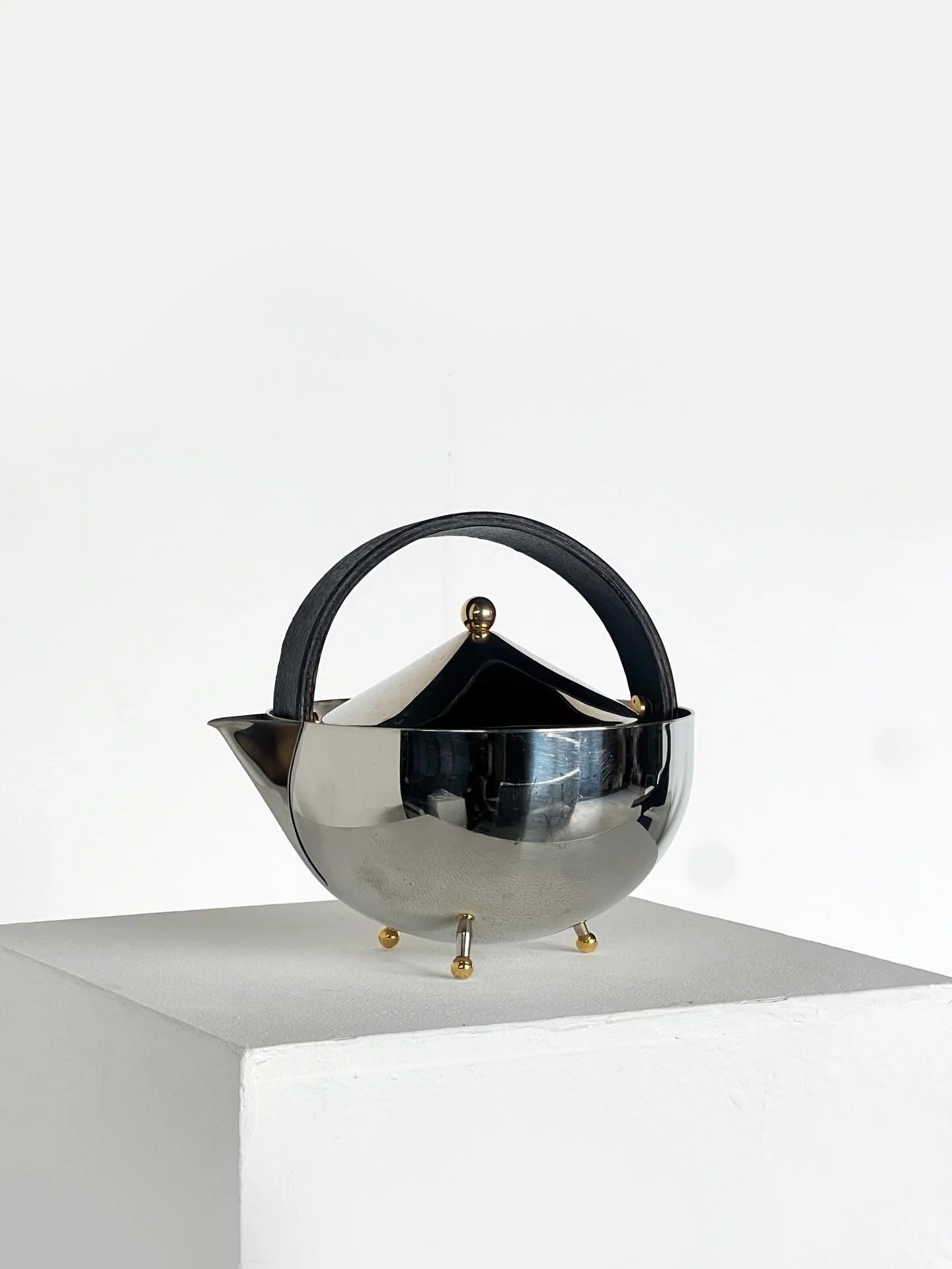 Carsten Jorgensen teapot, 1986 for Bodum of Switzerland.

A sculptural teapot defined by its reflective stainless-steel body, arched handle and precise geometric lid. The form balances softness and structure, with subtle brass details elevating on ba