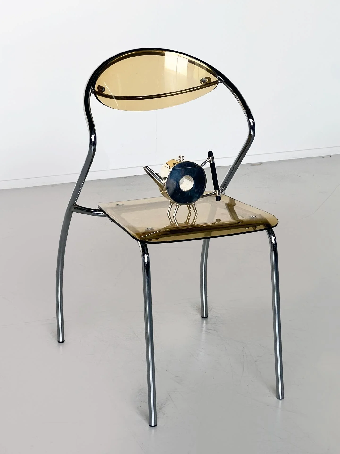 New: Smoked acrylic chair, chrome tubular frame with smoked acrylic seat and back.
A continuous line forms the structure, giving the chair a light, almost graphic presence.

Available for sale + hire via the website 

Late 20th century, Italian