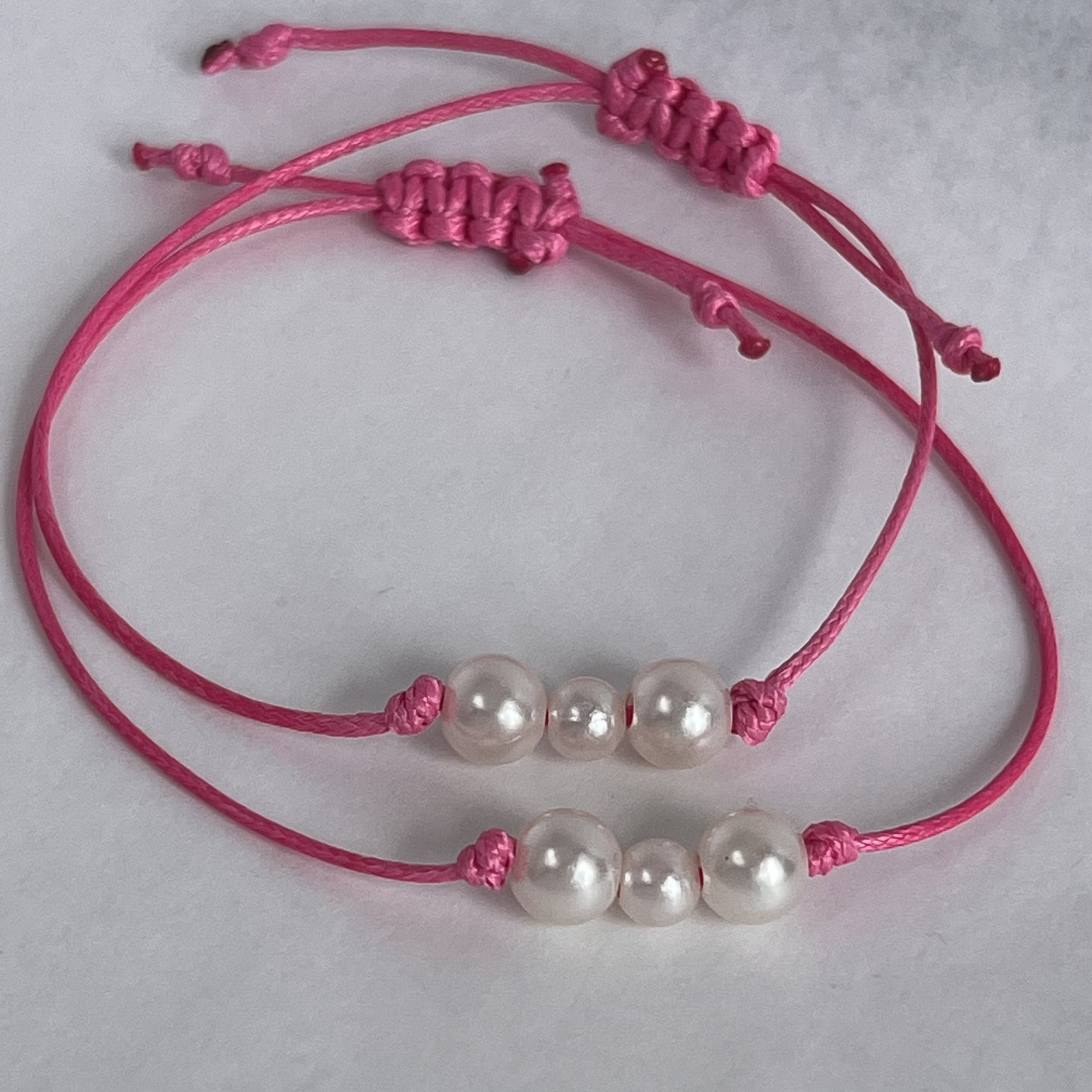 Minimalist handmade bracelet with pearl-style bead on pink cord