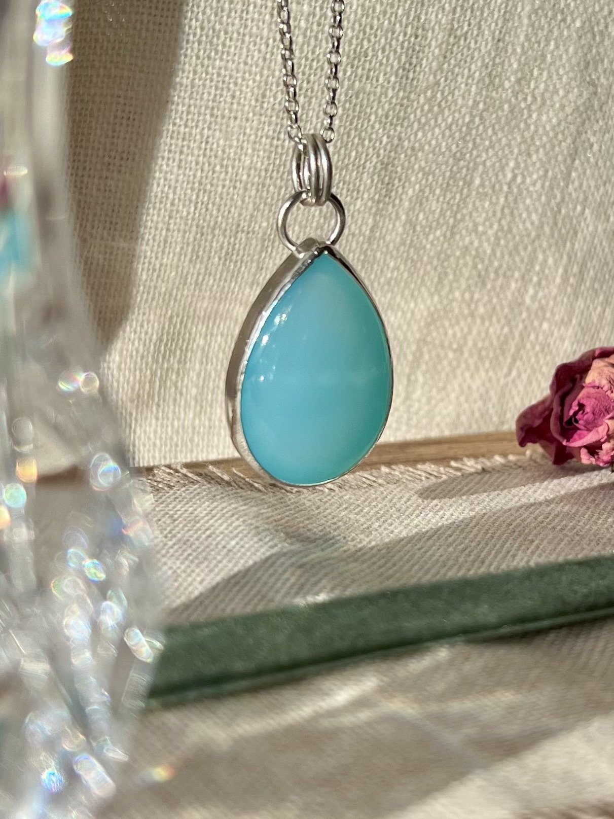Handmade teardrop pendant featuring a smooth aqua chalcedony cabochon set in sterling silver, minimalist and elegant design.