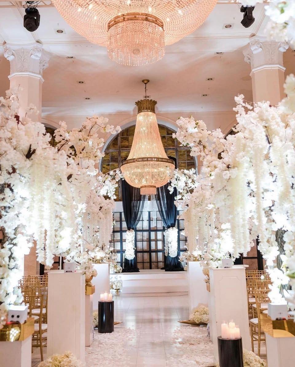 An aisle worthy of the moment. 🤍

Towering white blooms, glowing chandeliers, and dramatic black draping created a beautiful setting for &ldquo;I do.&rdquo;

With planning by Events by Mesita and florals and decor by lebamstudioweddingdesign, every 