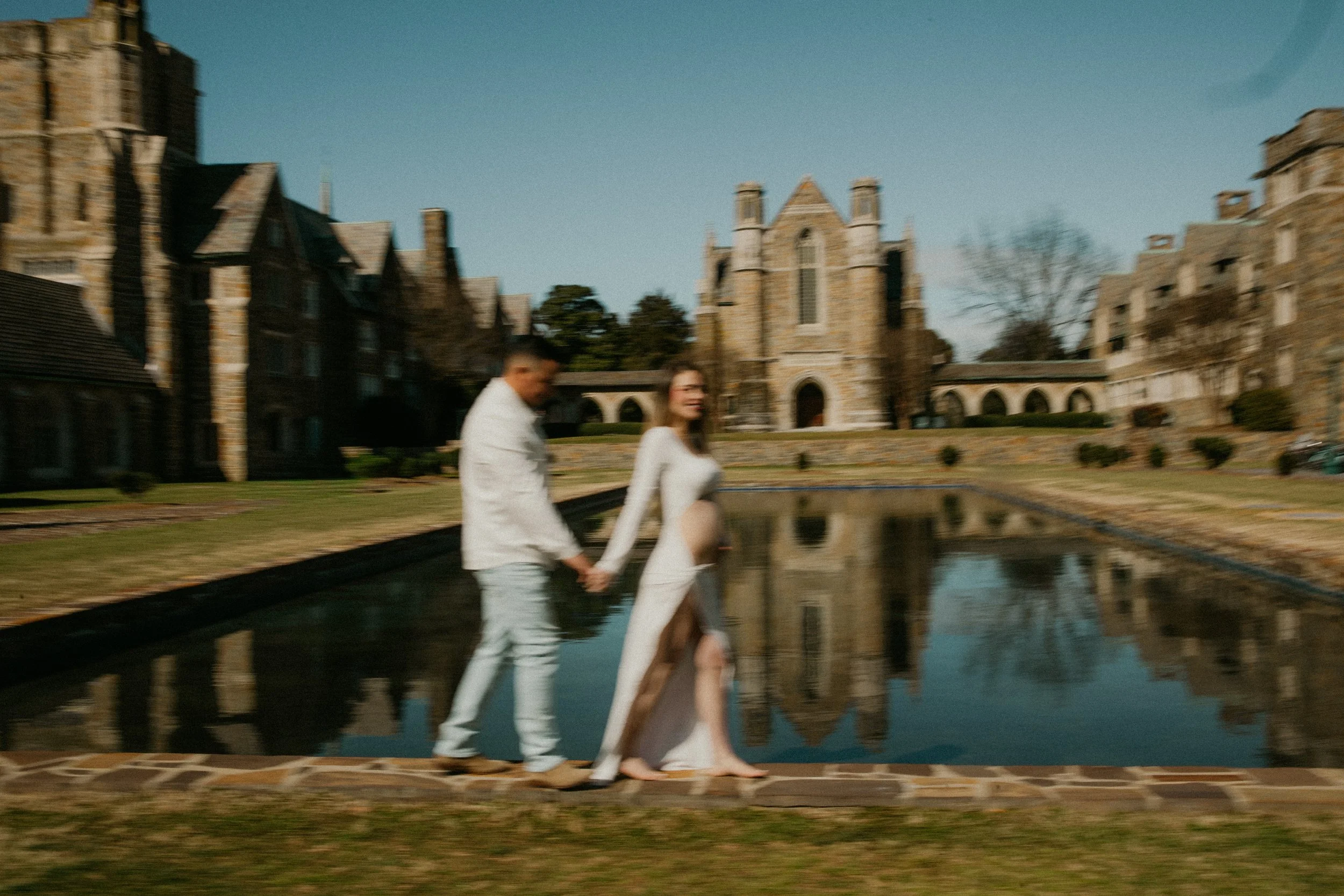 Couple walking beside reflecting pool at historic campus