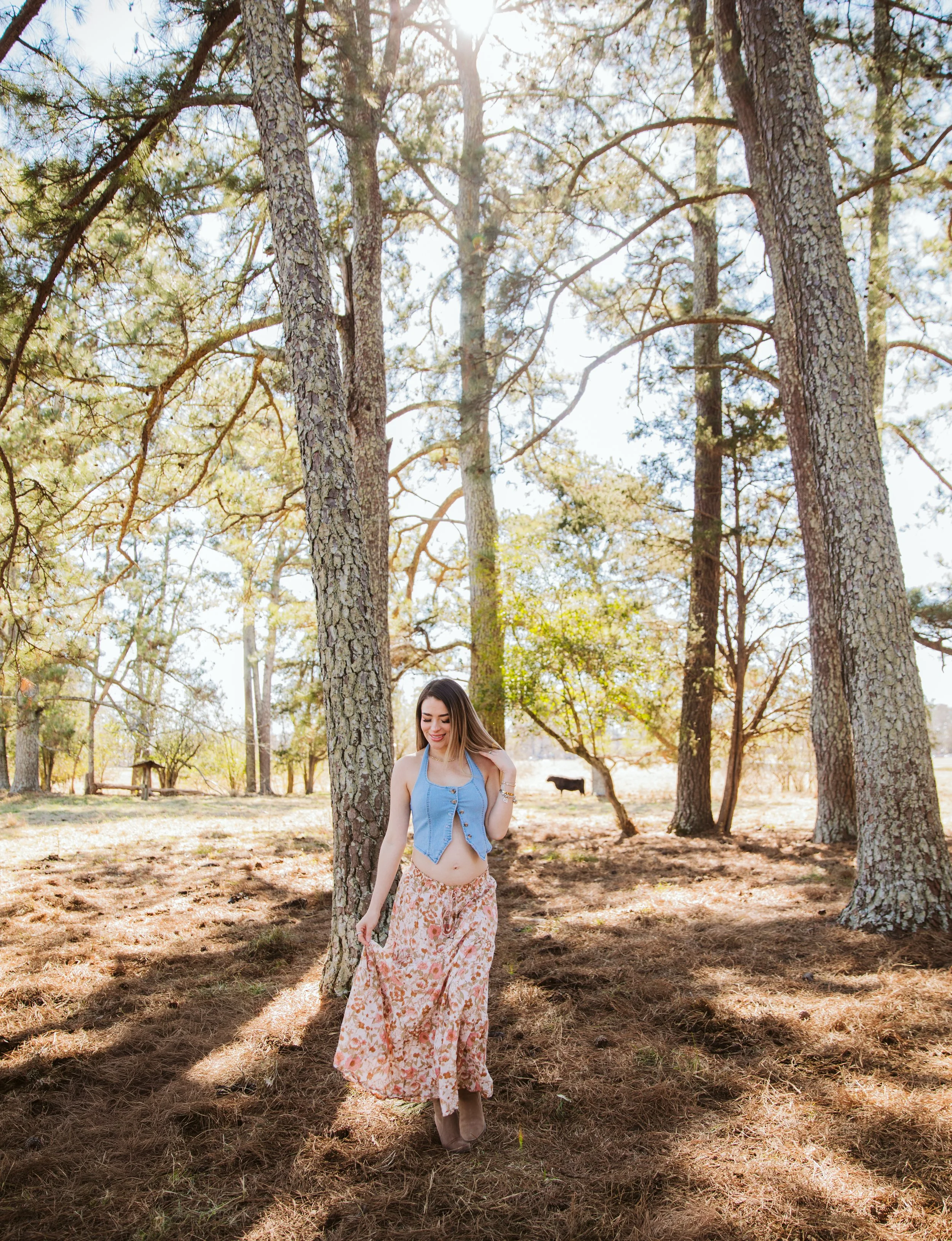 ortrait of woman standing among tall pine trees during lifestyle photoshoot